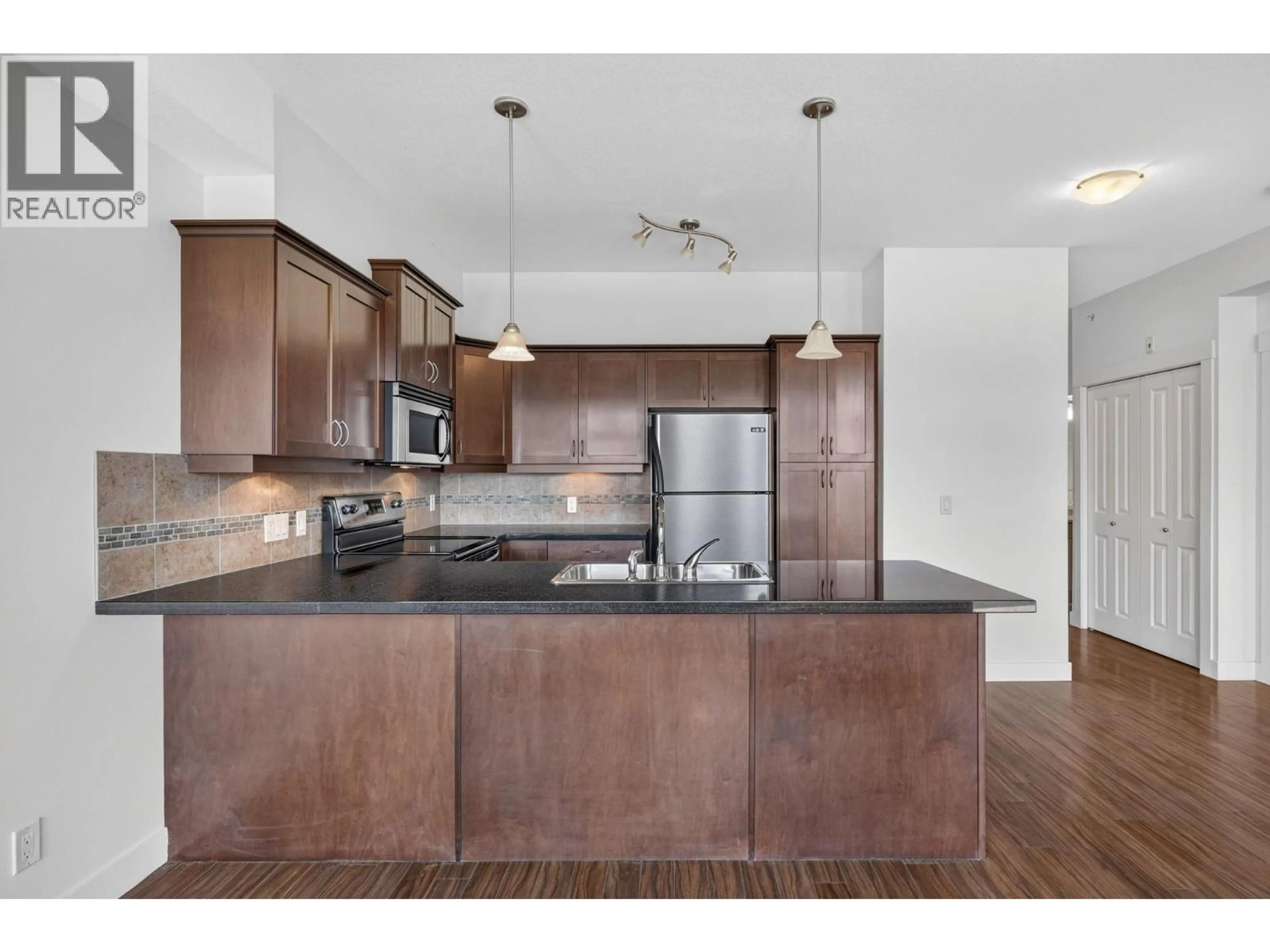 Open concept kitchen, wood/laminate floor for 410 - 3533 CARRINGTON ROAD, West Kelowna British Columbia V4T2Z9