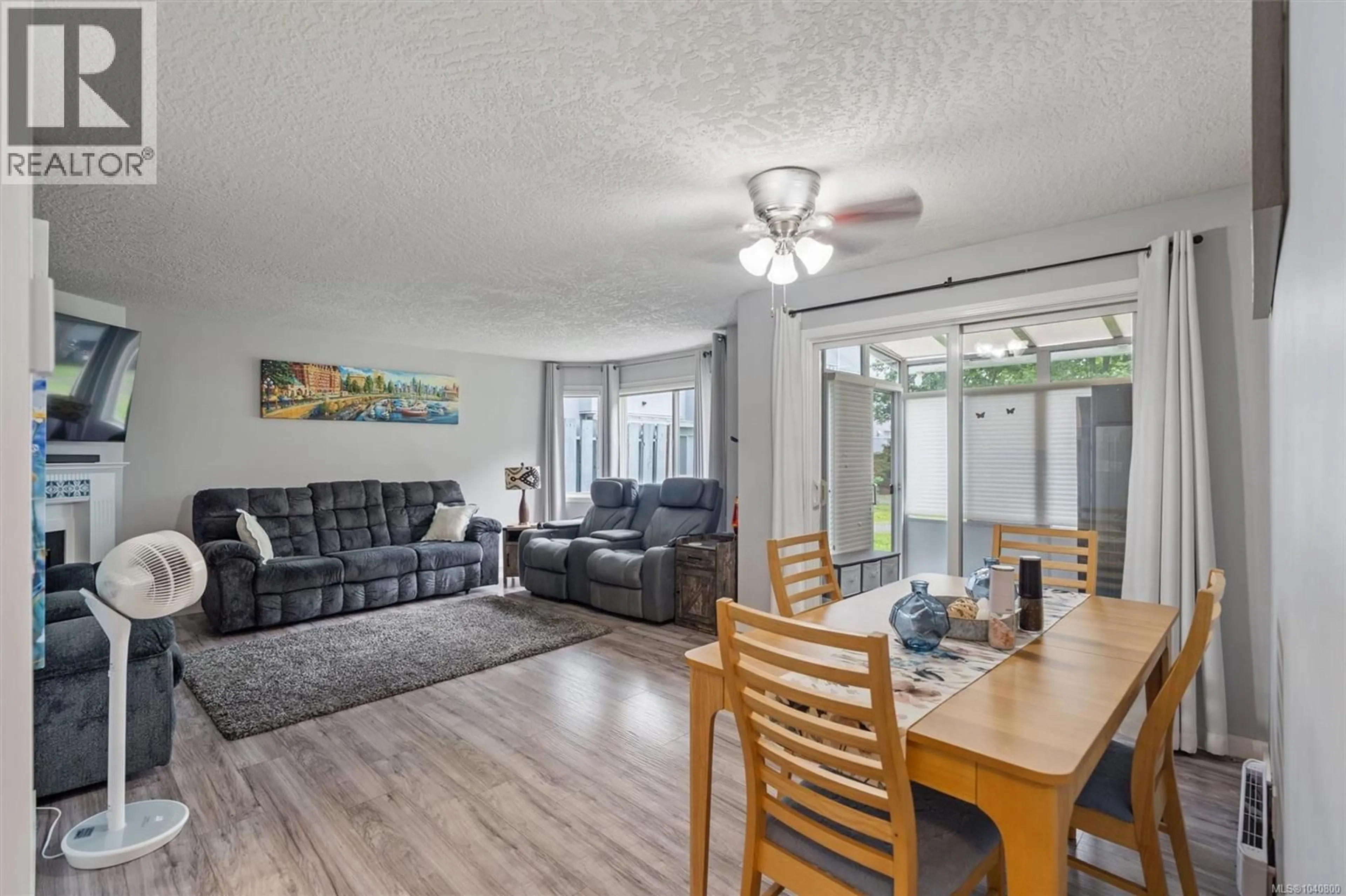 Living room with furniture, wood/laminate floor for 102 - 3931 SHELBOURNE STREET, Saanich British Columbia V8P4H9