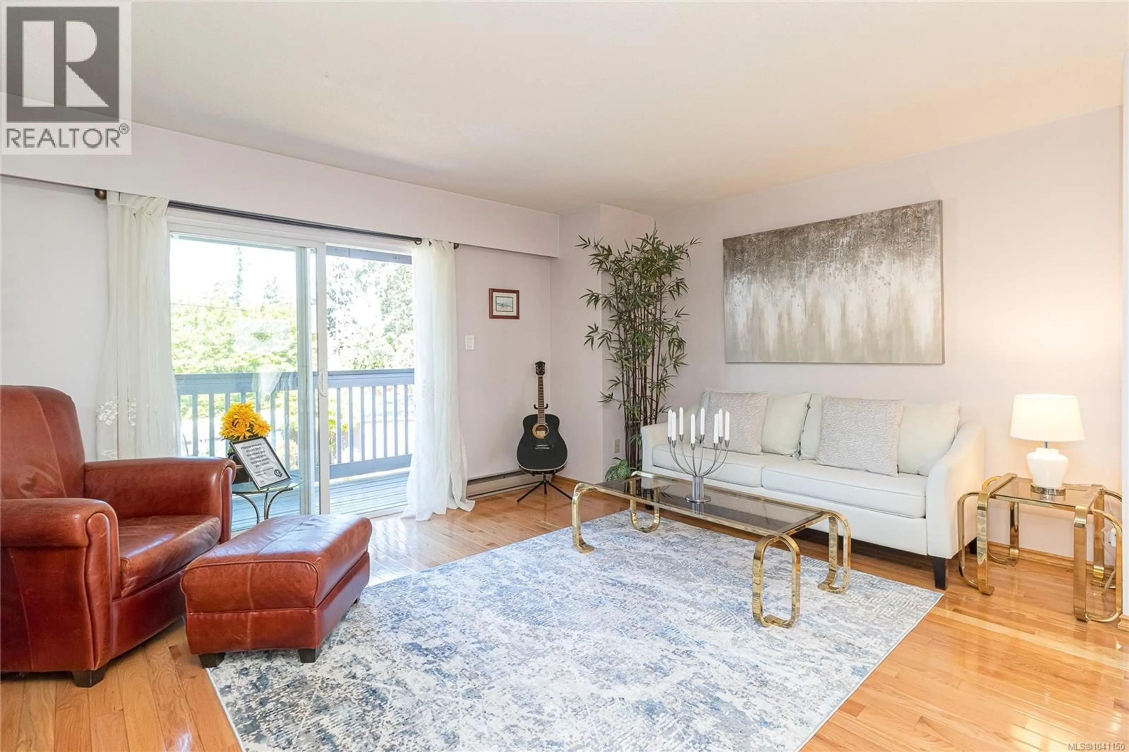 Living room with furniture, wood/laminate floor for 1 - 4391 TORQUAY DRIVE, Saanich British Columbia V8N3L3