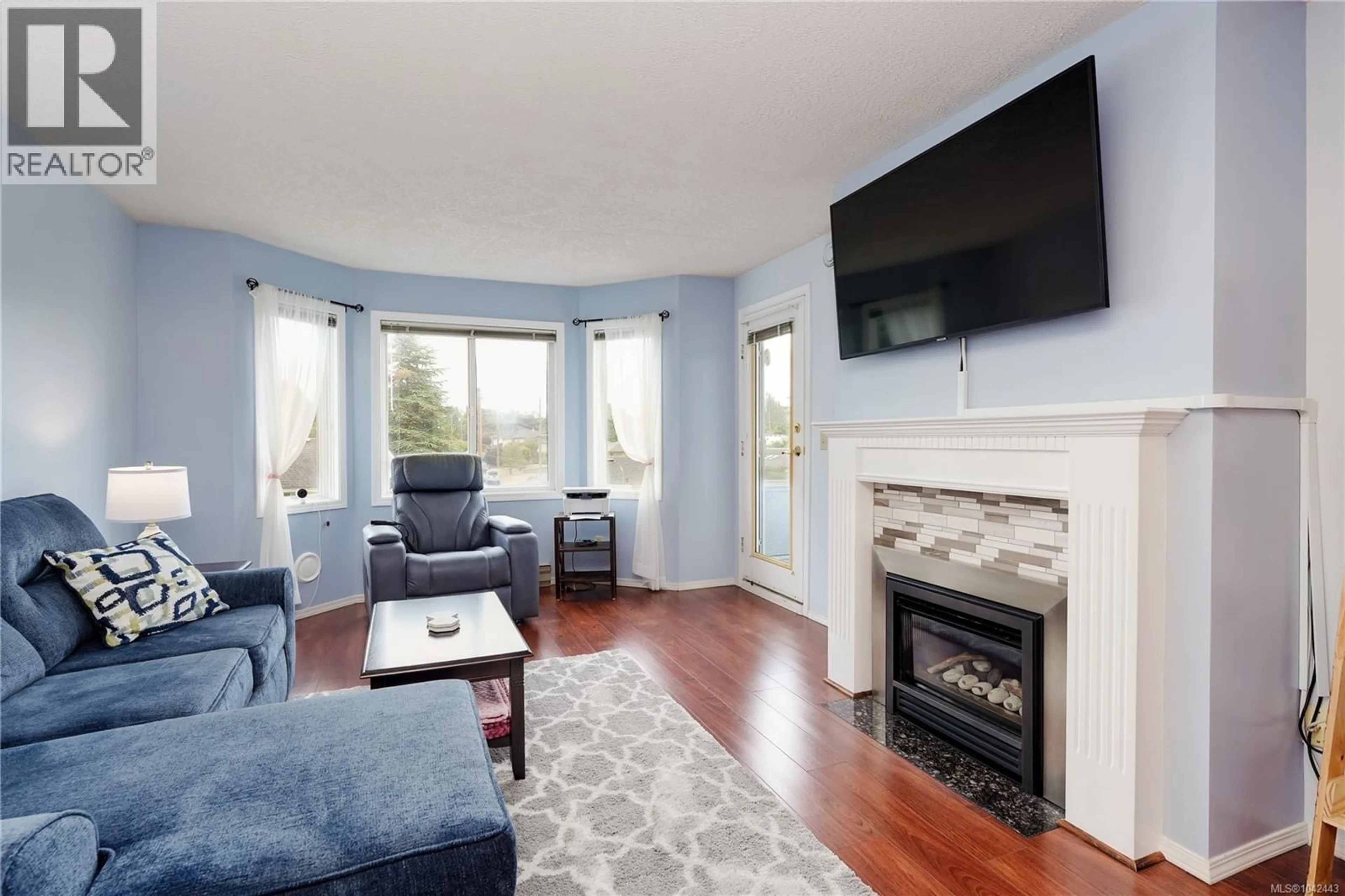 Living room with furniture, wood/laminate floor for 308 - 3921 SHELBOURNE STREET, Saanich British Columbia V8P4H9