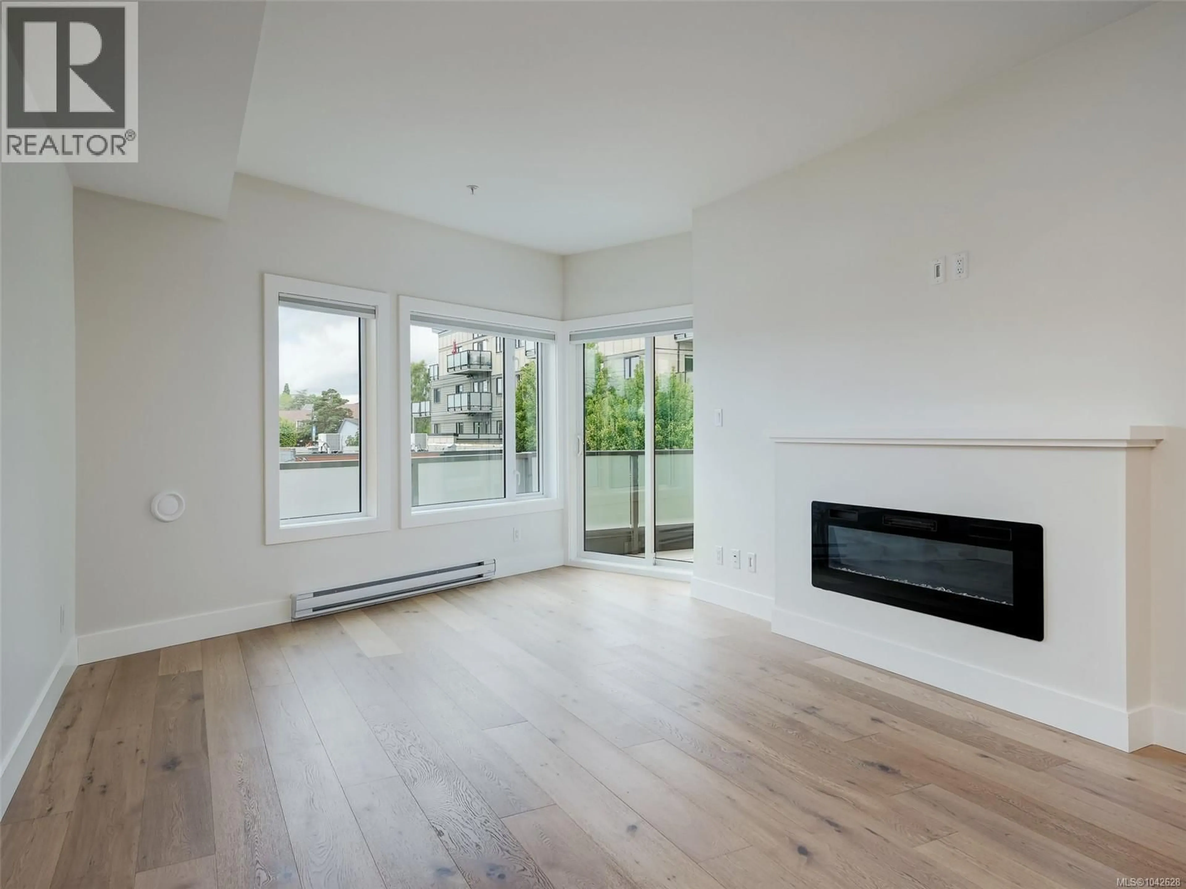 Living room with furniture, wood/laminate floor for 203 - 7098 WALLACE DRIVE, Central Saanich British Columbia V8M1G9