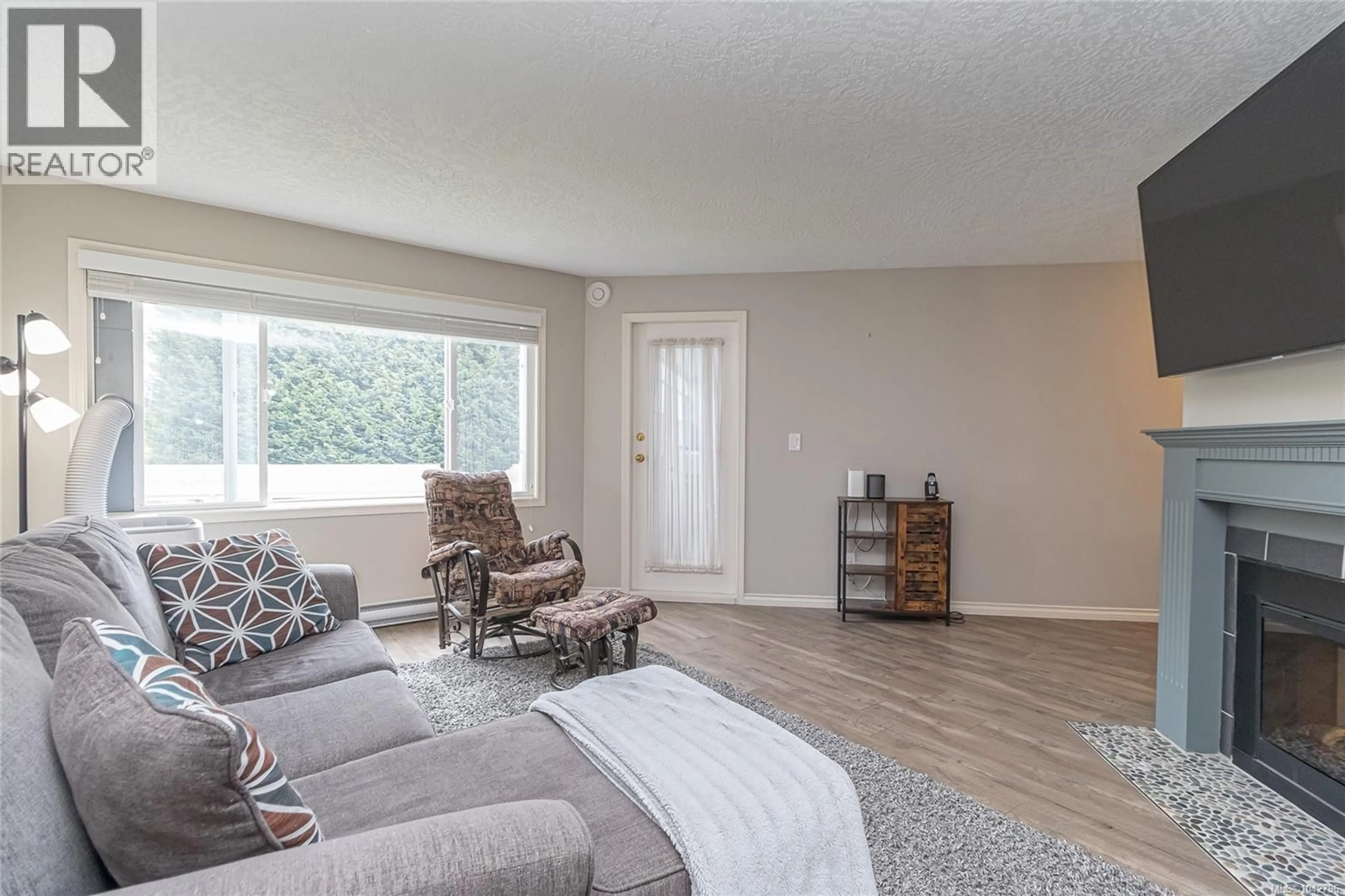 Living room with furniture, wood/laminate floor for 204 - 3931 SHELBOURNE STREET, Saanich British Columbia V8P4H9