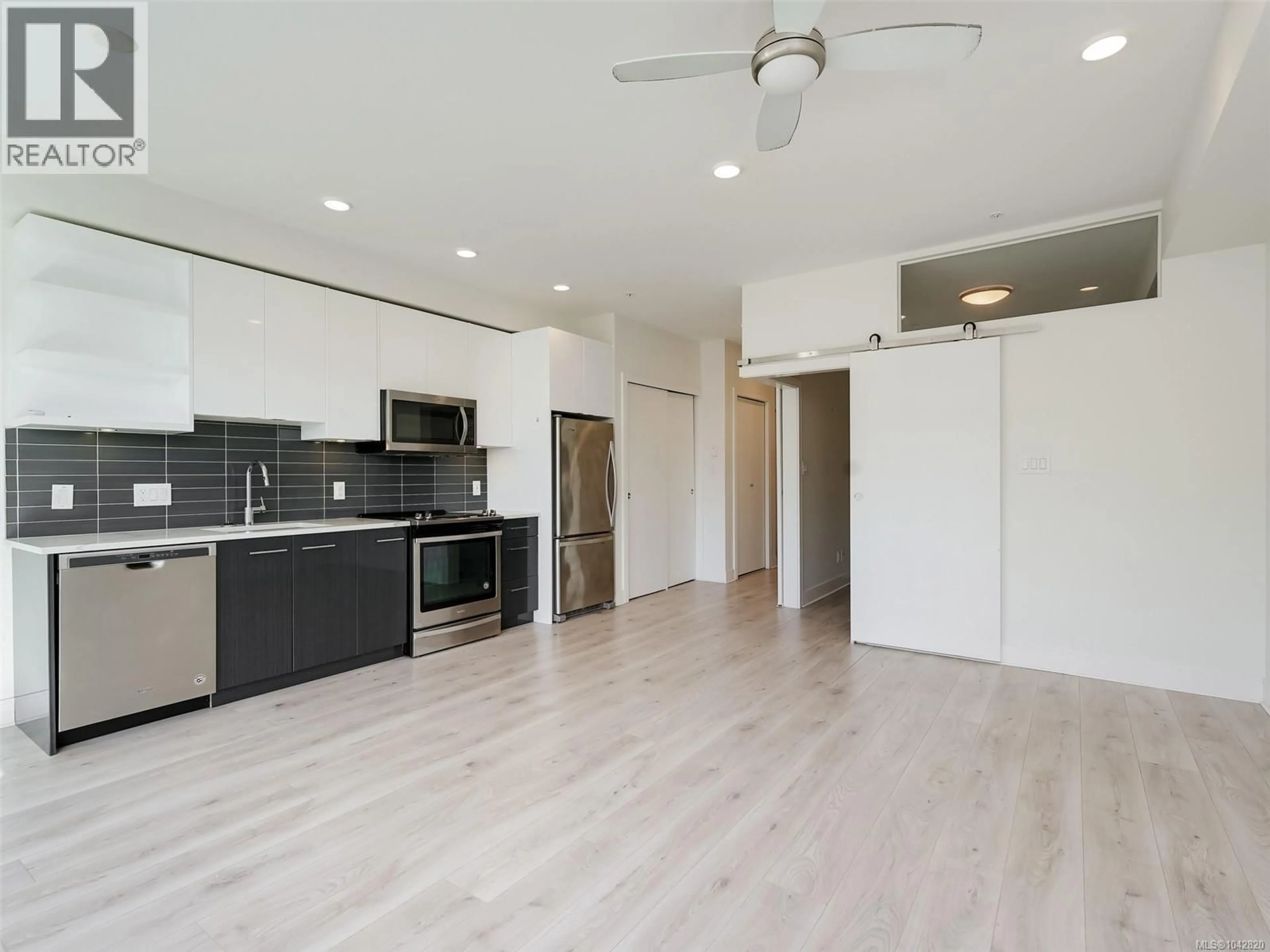 Open concept kitchen, wood/laminate floor for 407 - 1311 LAKEPOINT WAY, Langford British Columbia V9B0S7