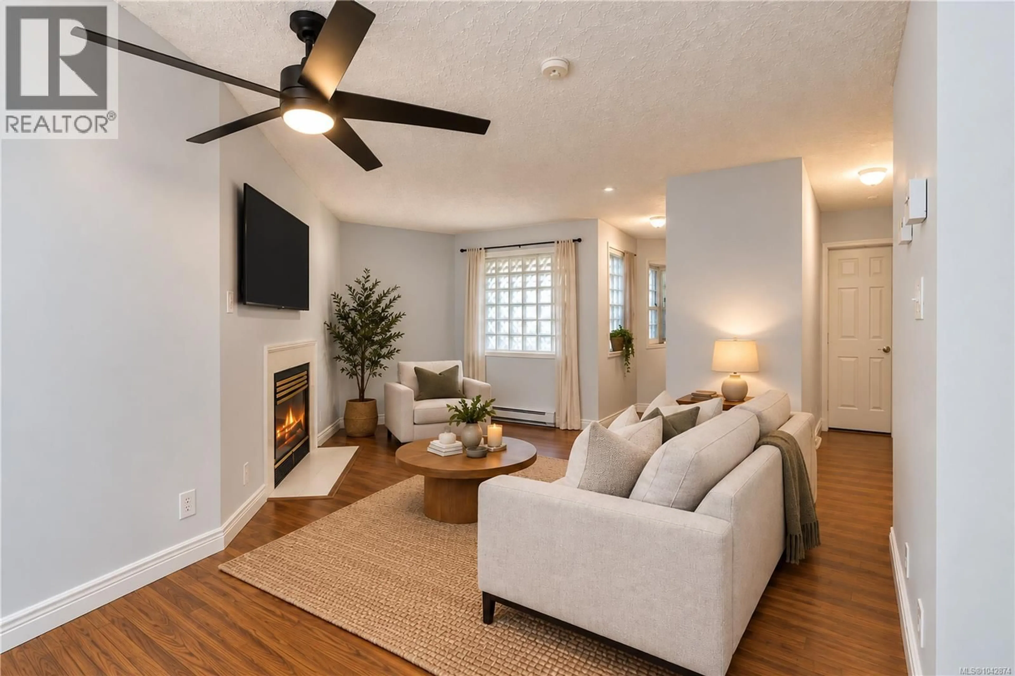 Living room with furniture, wood/laminate floor for 101 - 2710 GROSVENOR ROAD, Victoria British Columbia V8T3M9