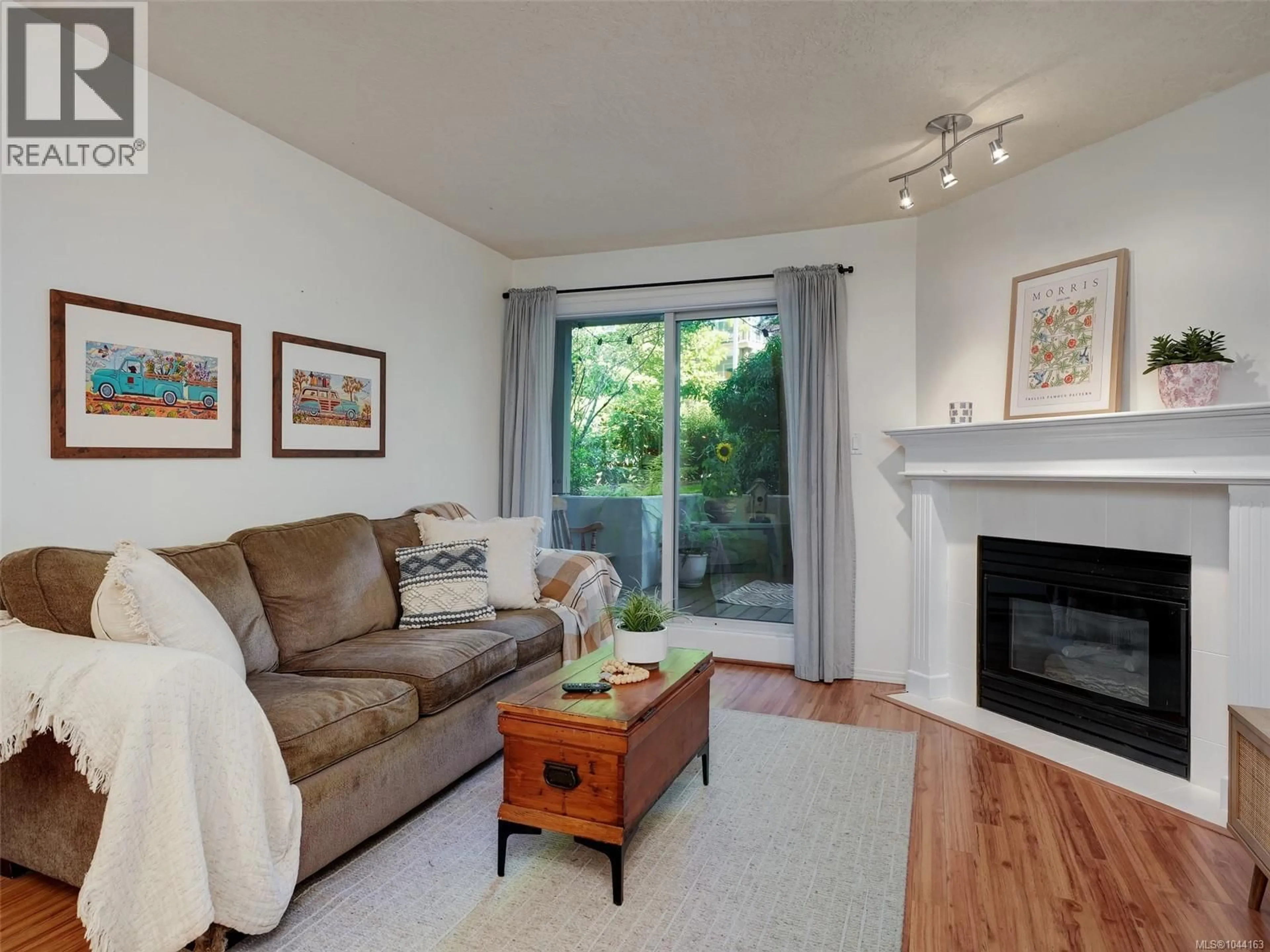 Living room with furniture, wood/laminate floor for 110 - 494 MARSETT PLACE, Saanich British Columbia V8Z4J1