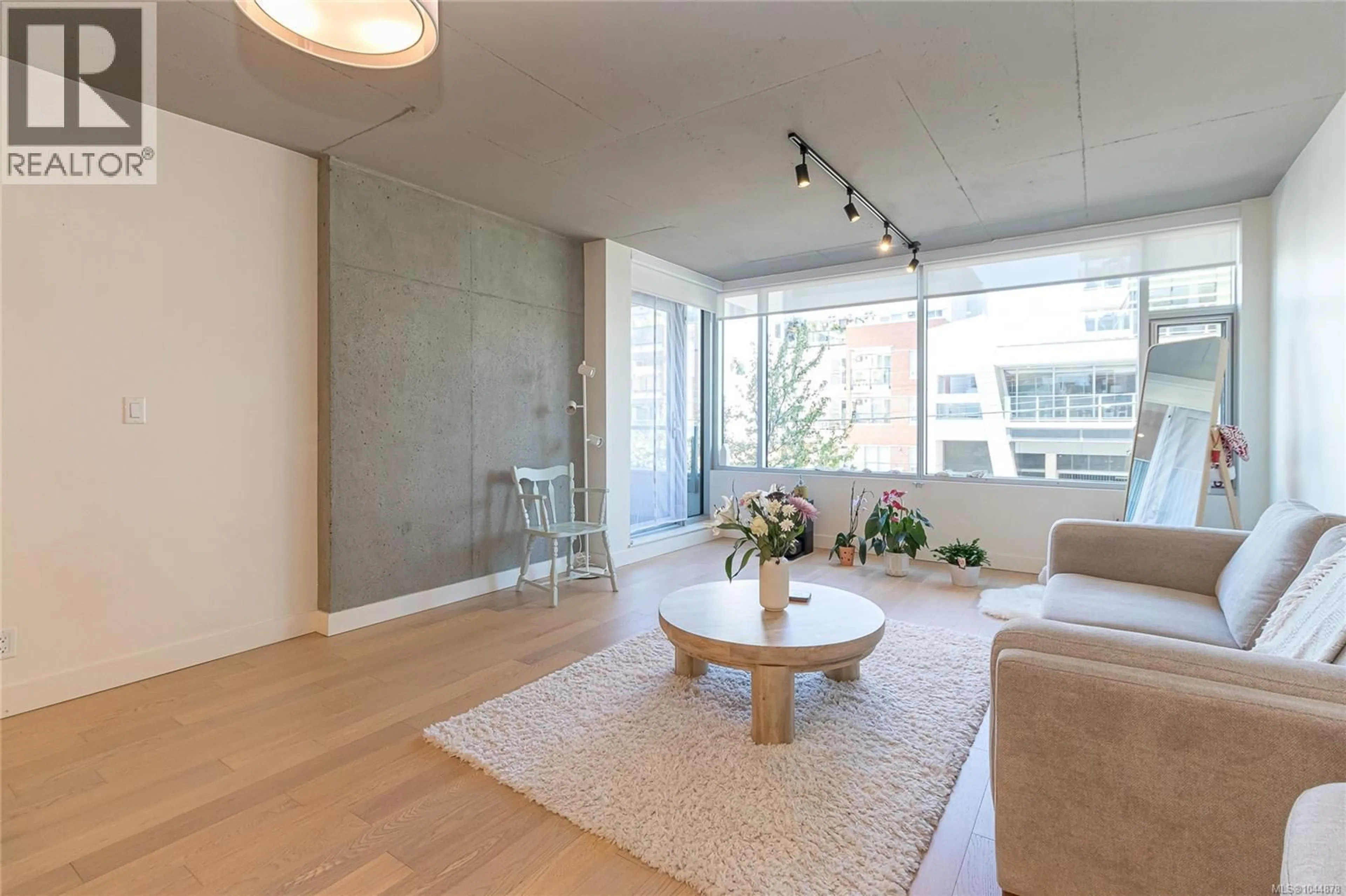 Living room with furniture, wood/laminate floor for 205 - 989 JOHNSON STREET, Victoria British Columbia V8V0E3