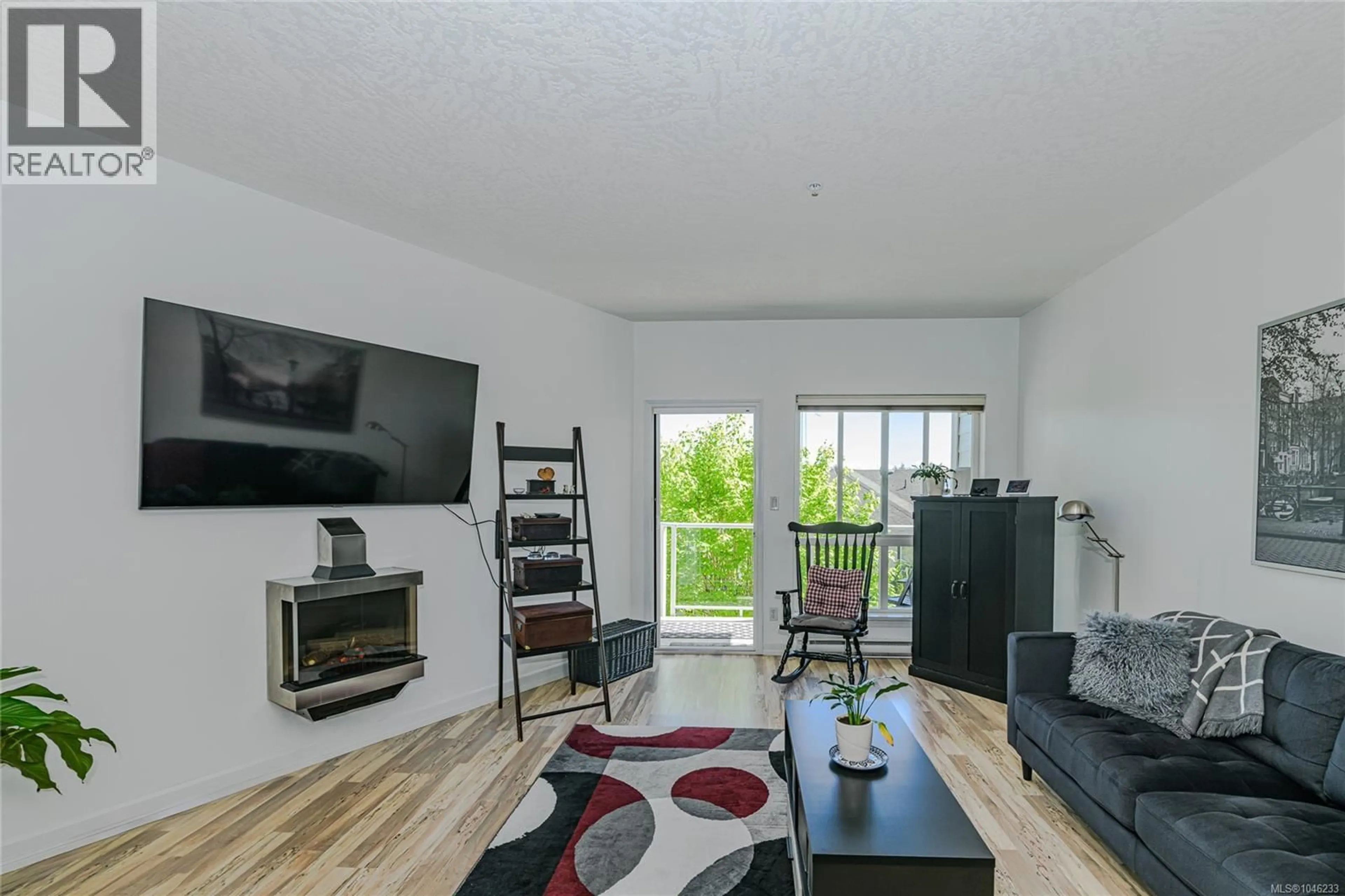 Living room with furniture, wood/laminate floor for 205 - 3915 CAREY ROAD, Saanich British Columbia V8Z1Z6