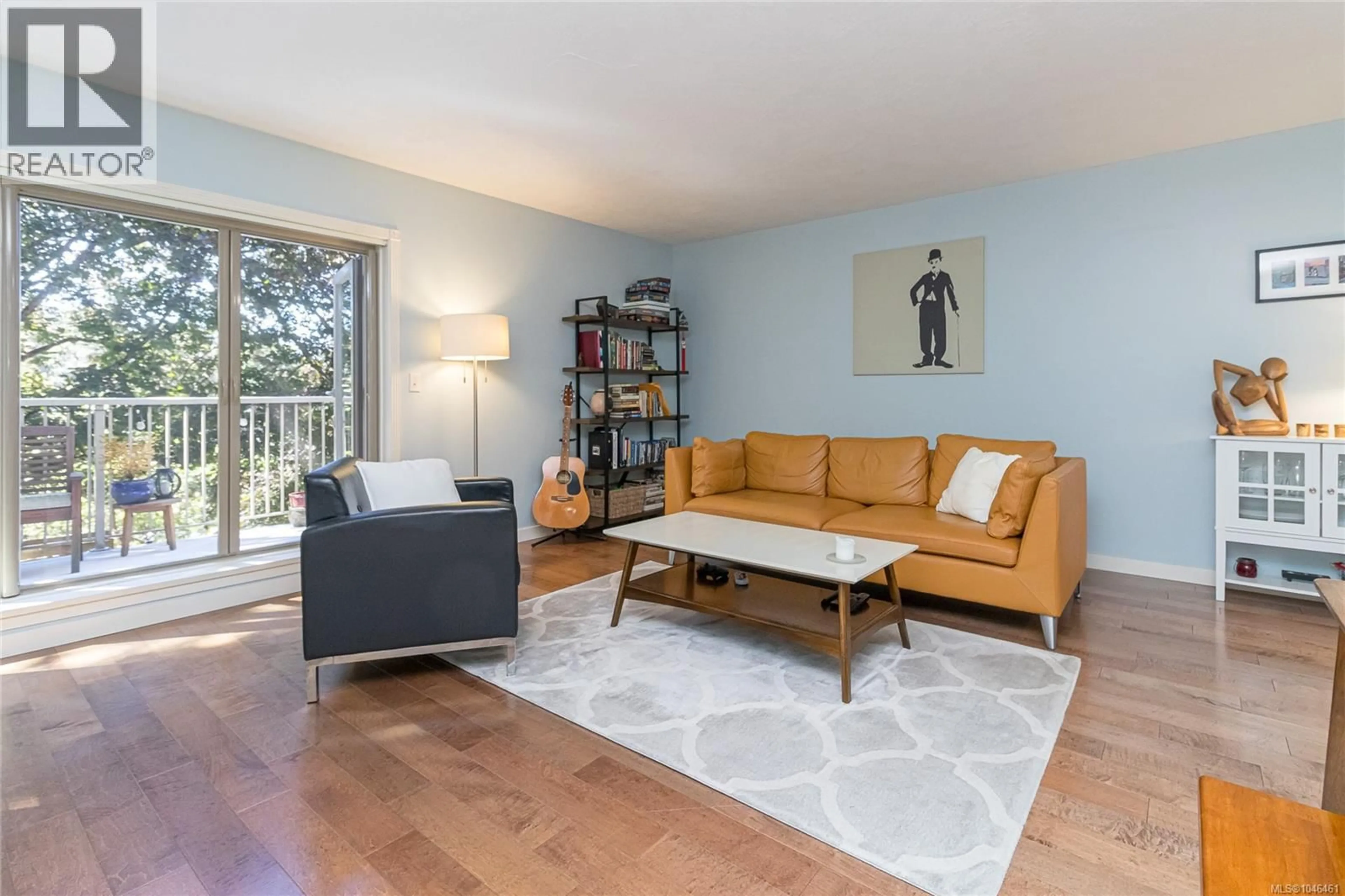 Living room with furniture, wood/laminate floor for 208 - 3880 QUADRA STREET, Saanich British Columbia V8X1H8