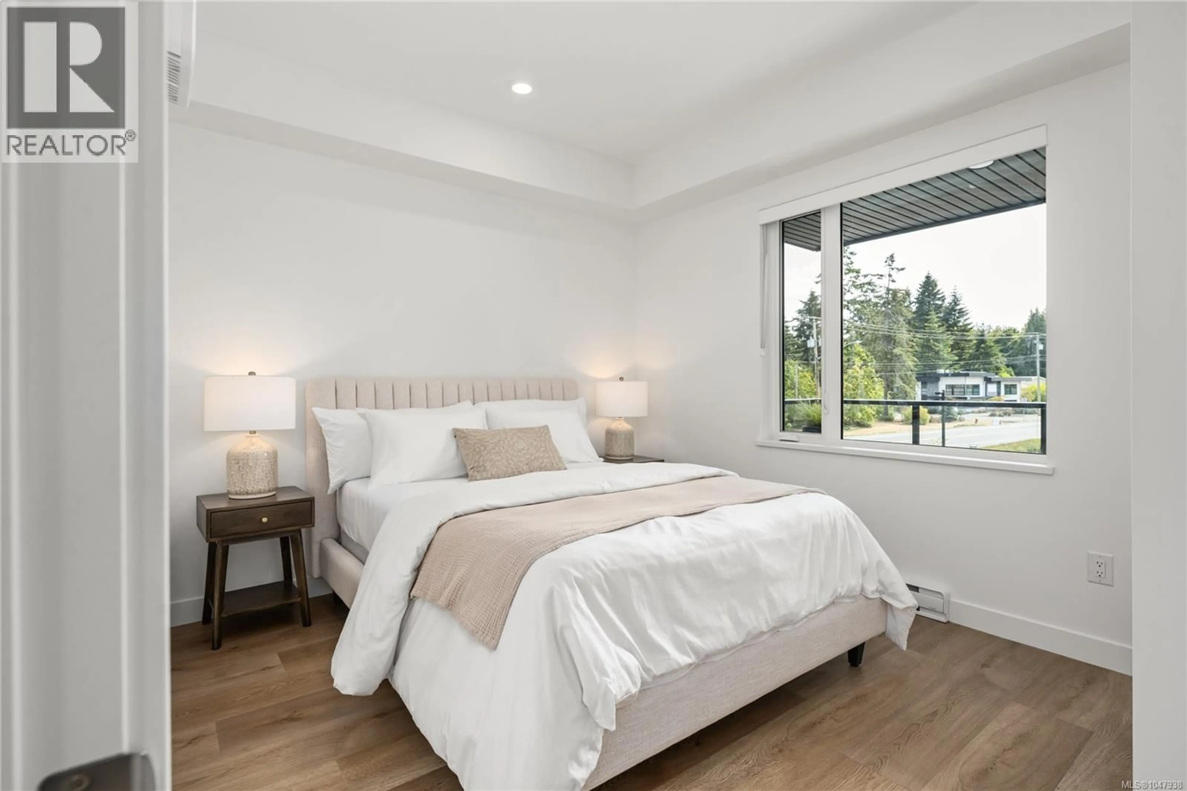 Bedroom with bed, wood/laminate floor for 203 - 7181 LANTZVILLE ROAD, Lantzville British Columbia V0R2H0