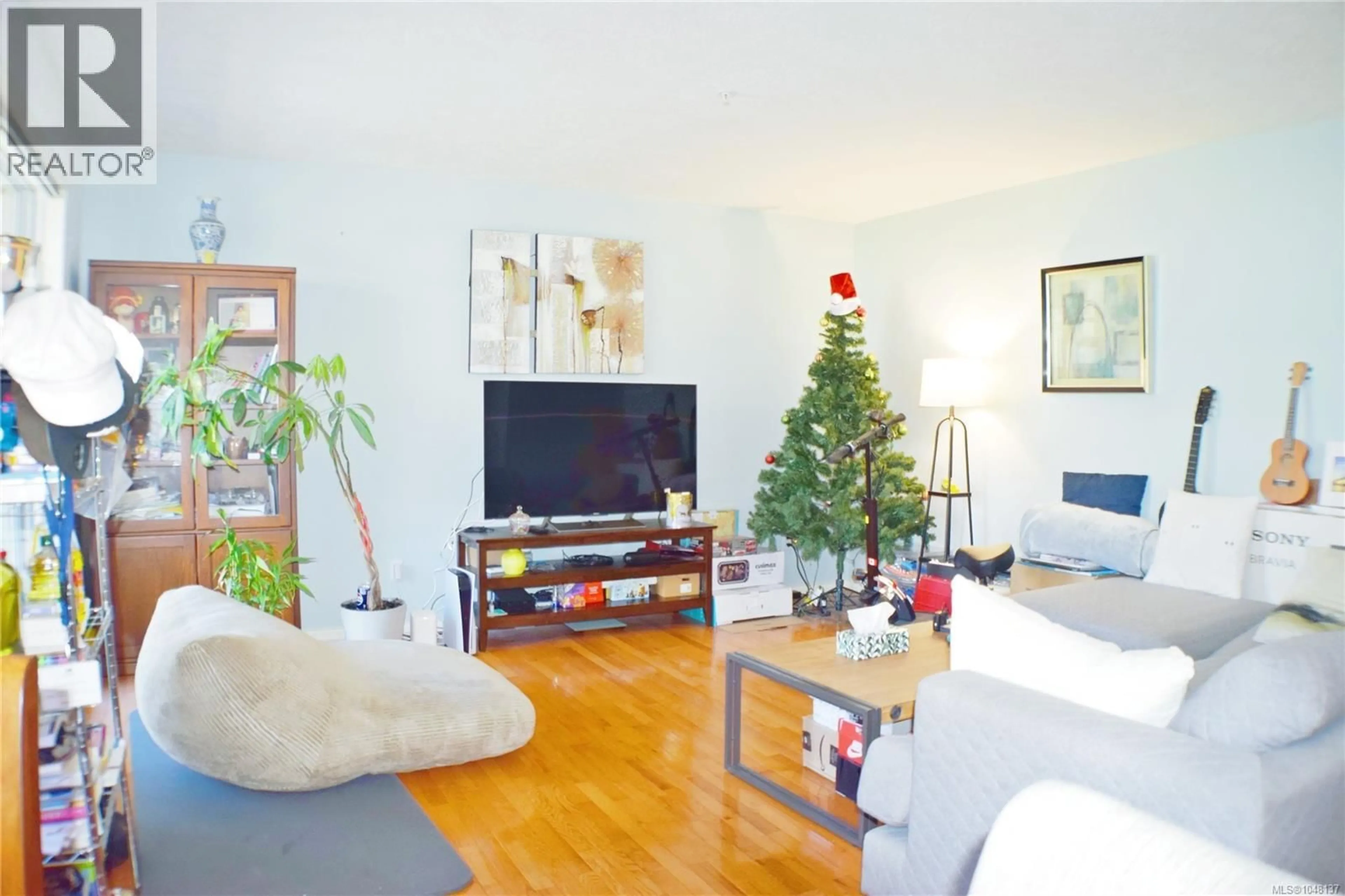 Living room with furniture, wood/laminate floor for 207 - 1694 CEDAR HILL CROSS ROAD, Saanich British Columbia V8P2P7