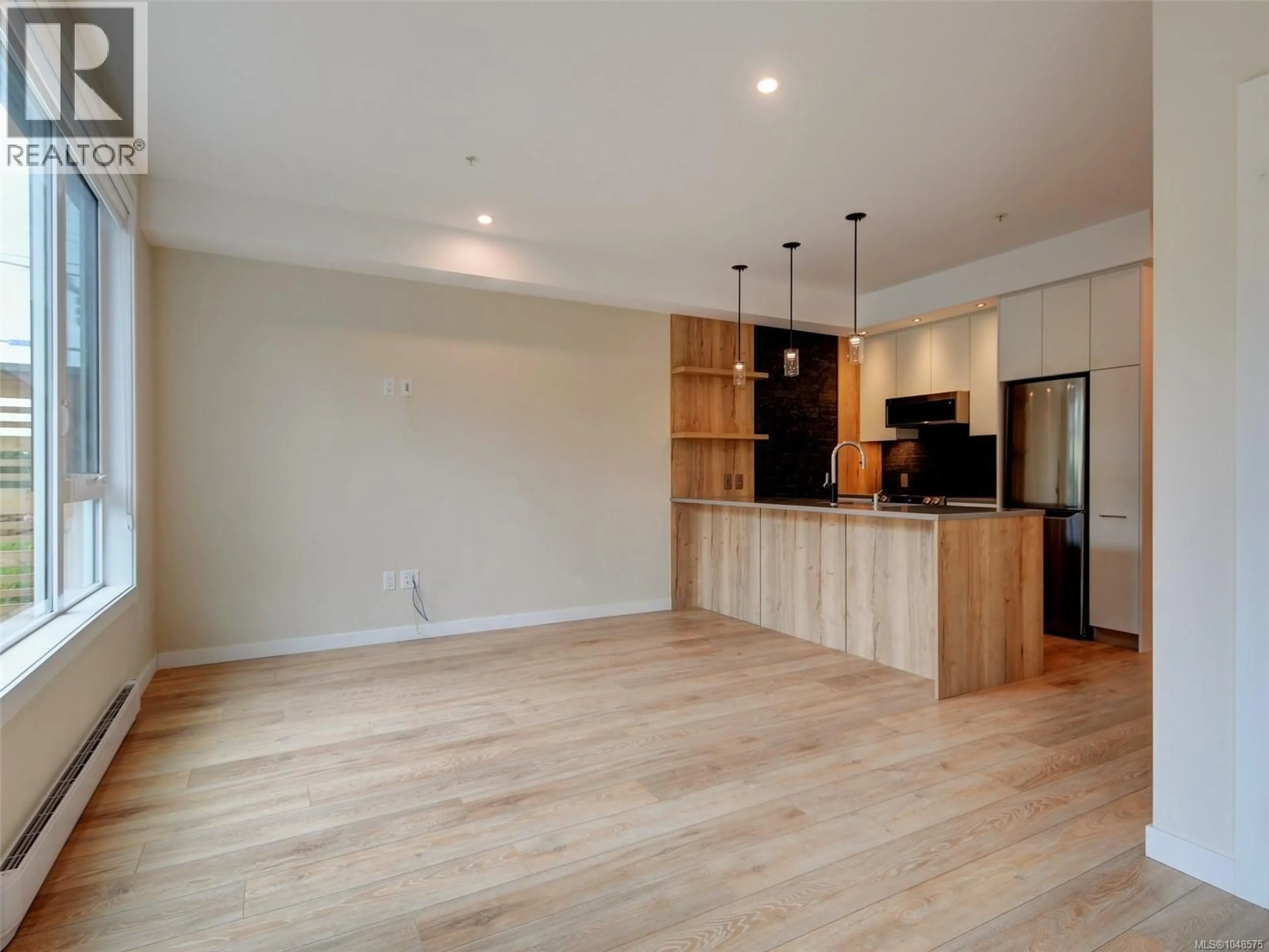 Open concept kitchen, wood/laminate floor for 101 - 1588 NORTH DAIRY ROAD, Saanich British Columbia V8T0E1