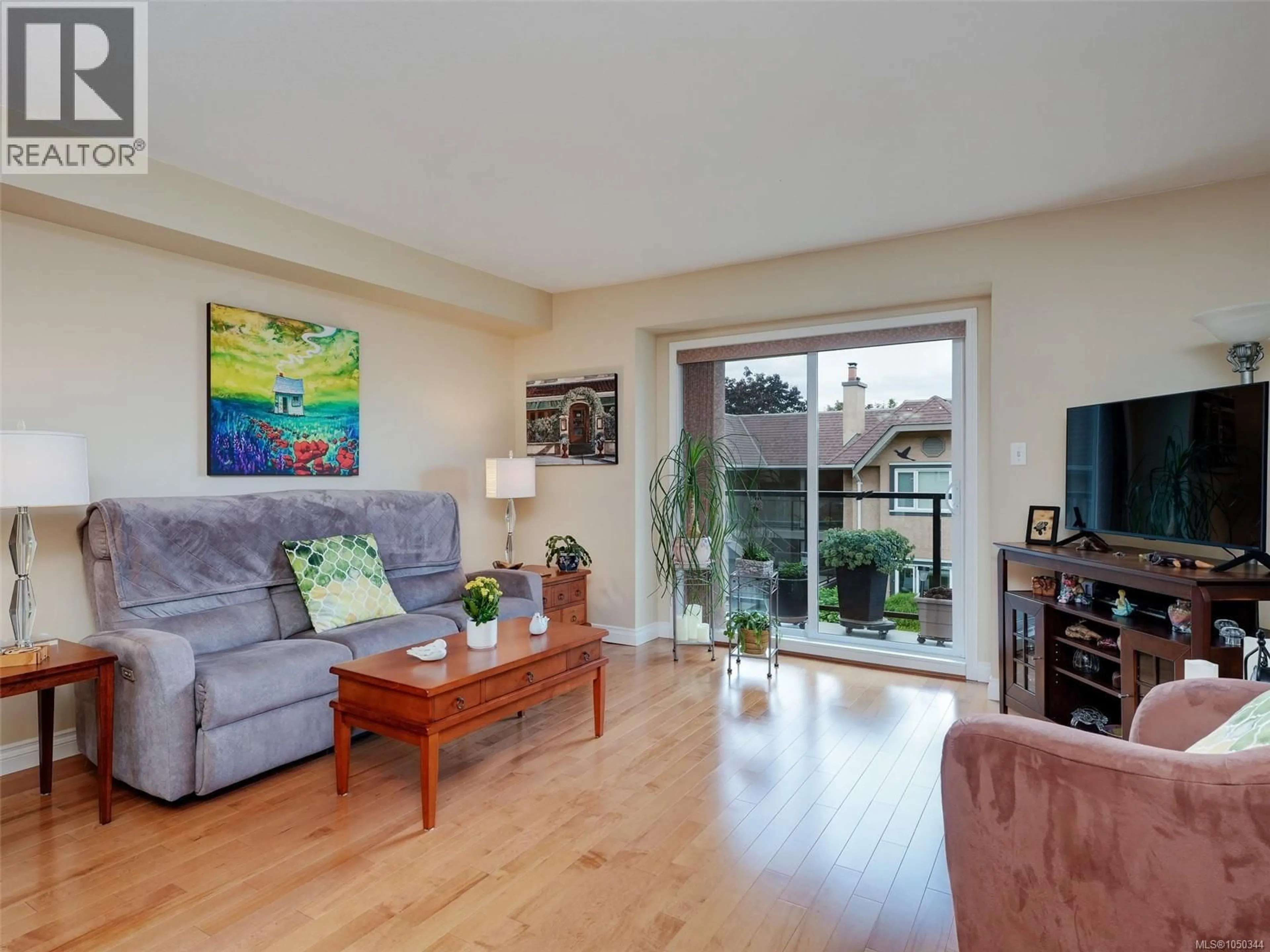 Living room with furniture, wood/laminate floor for 202 - 7070 WEST SAANICH ROAD, Central Saanich British Columbia V8M1P5