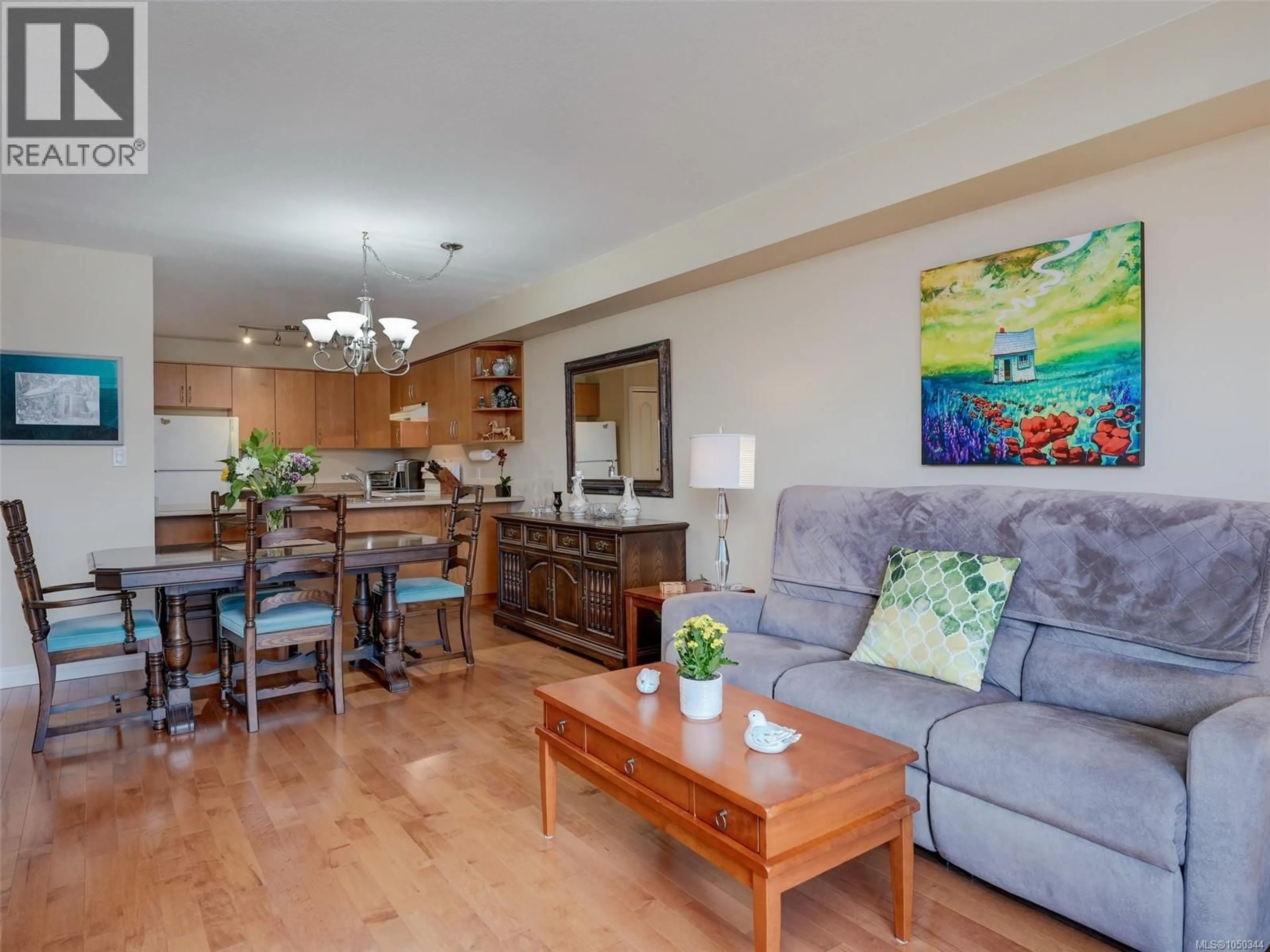Living room with furniture, wood/laminate floor for 202 - 7070 WEST SAANICH ROAD, Central Saanich British Columbia V8M1P5