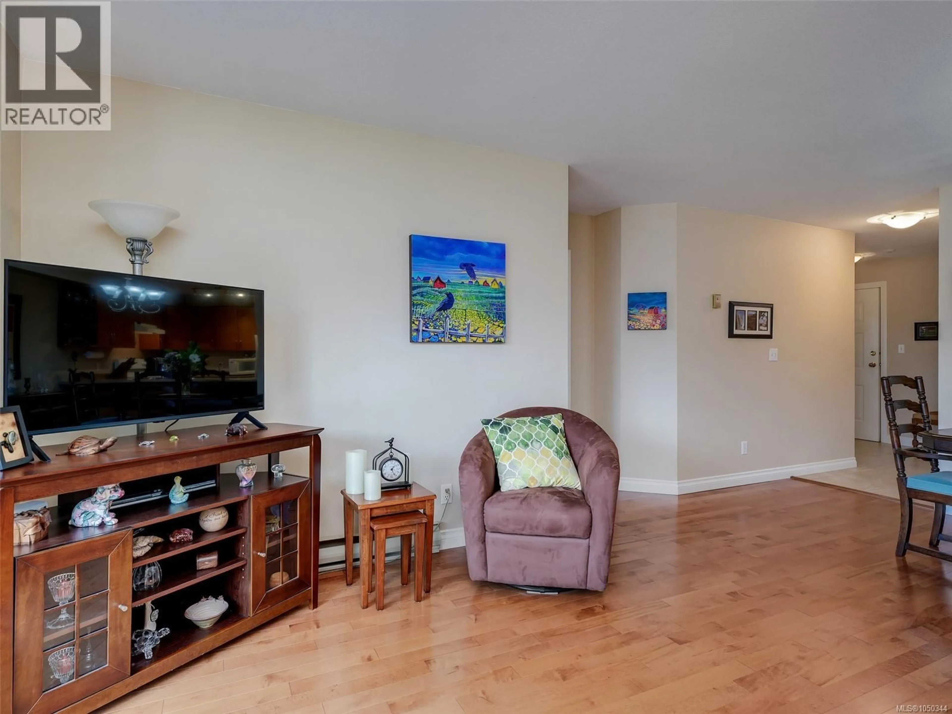 Living room with furniture, wood/laminate floor for 202 - 7070 WEST SAANICH ROAD, Central Saanich British Columbia V8M1P5