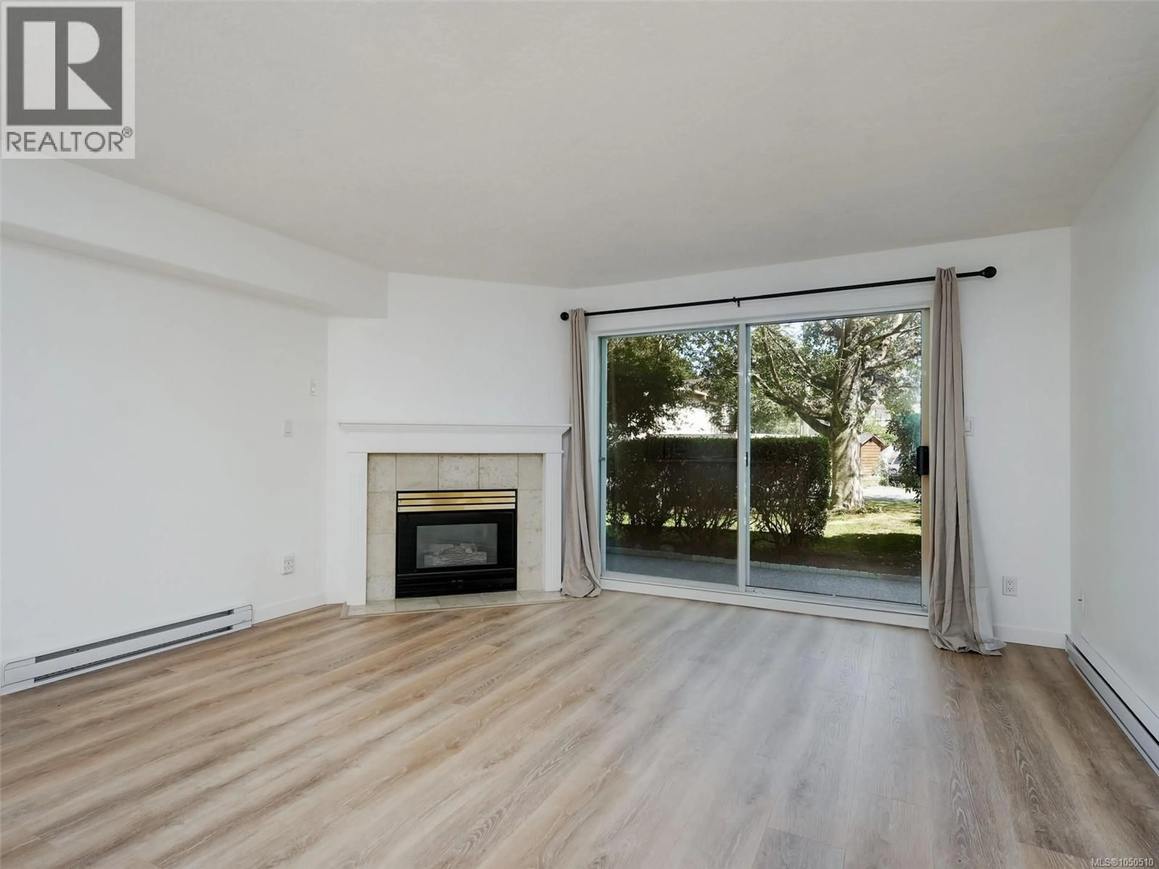 Living room with furniture, wood/laminate floor for 101 - 3724 HARRIET ROAD, Saanich British Columbia V8Z3T2