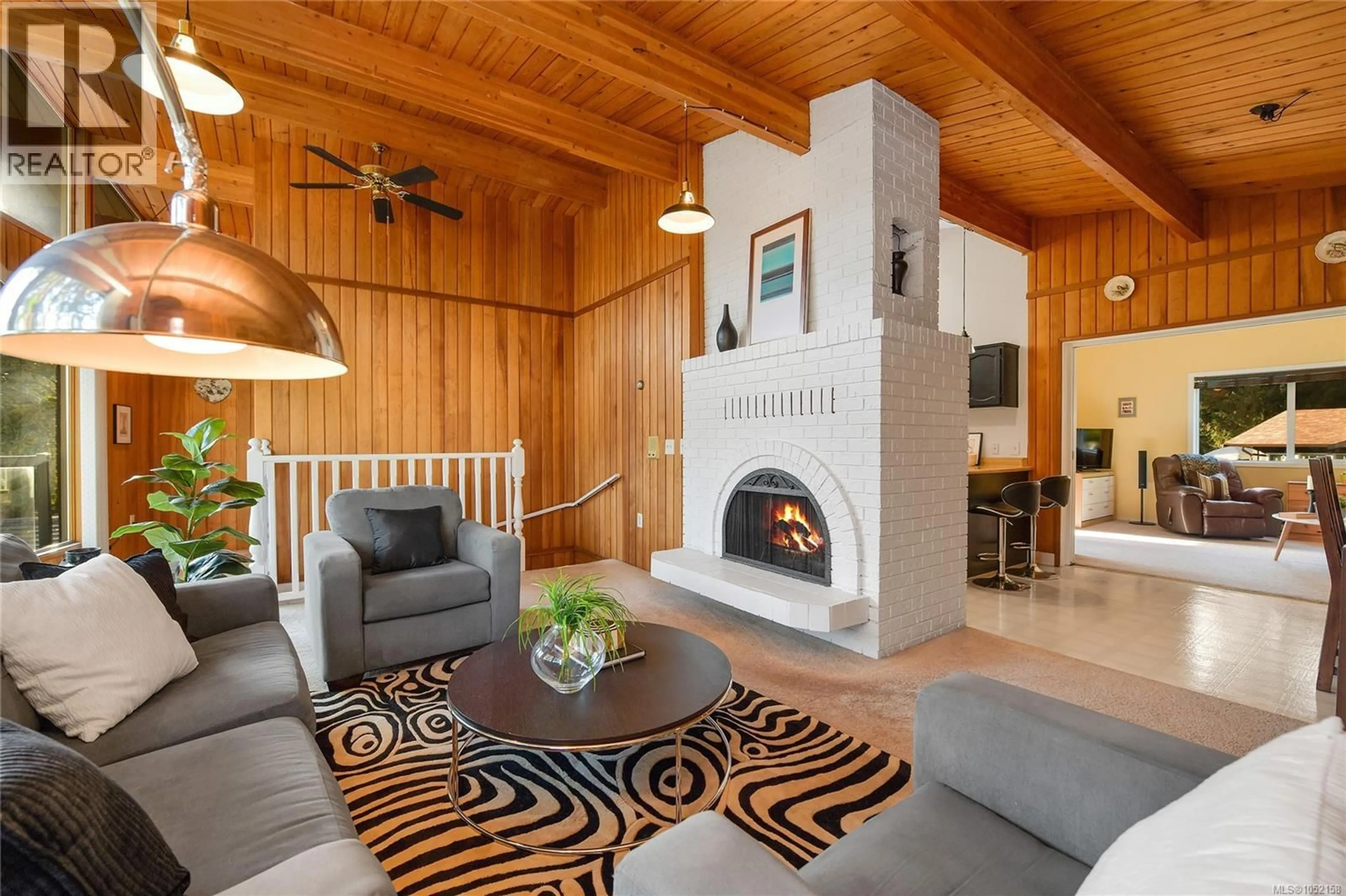 Living room with furniture, wood/laminate floor for 7036 CON-ADA ROAD, Central Saanich British Columbia V8M1E7
