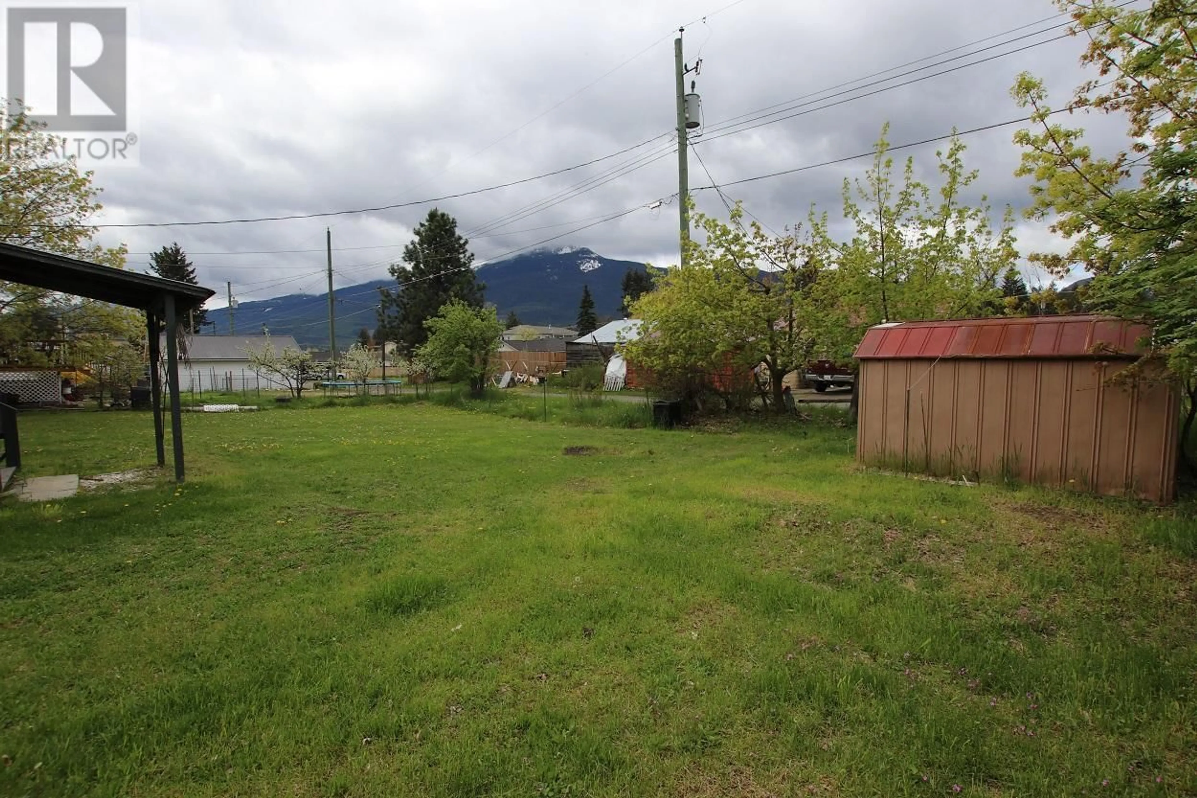 Frontside or backside of a home, the fenced backyard for 312 6TH Avenue, Nakusp British Columbia V0G1R0