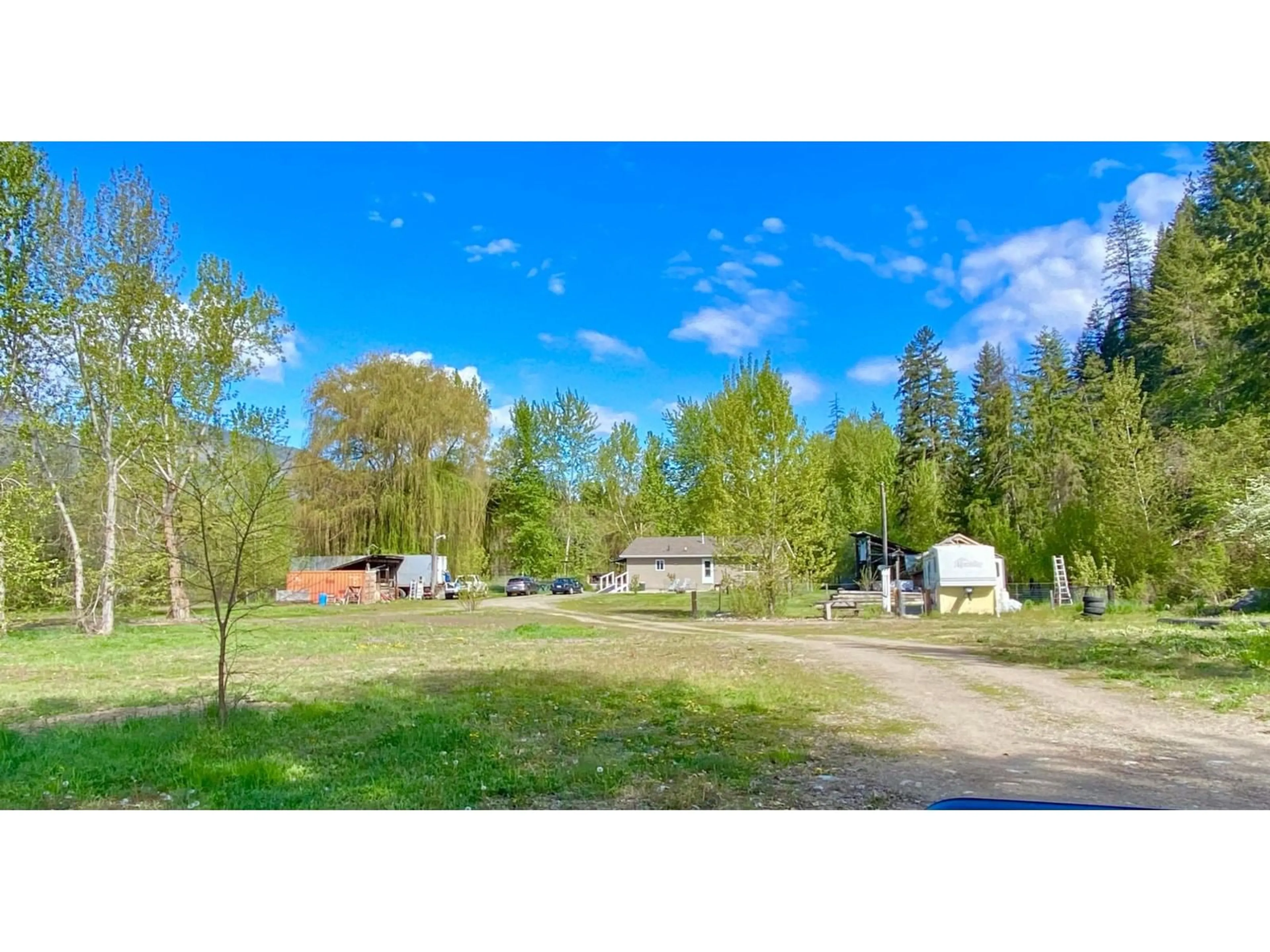 A pic from exterior of the house or condo, the fenced backyard for 1800 3 Highway, Christina Lake British Columbia V0H1E3