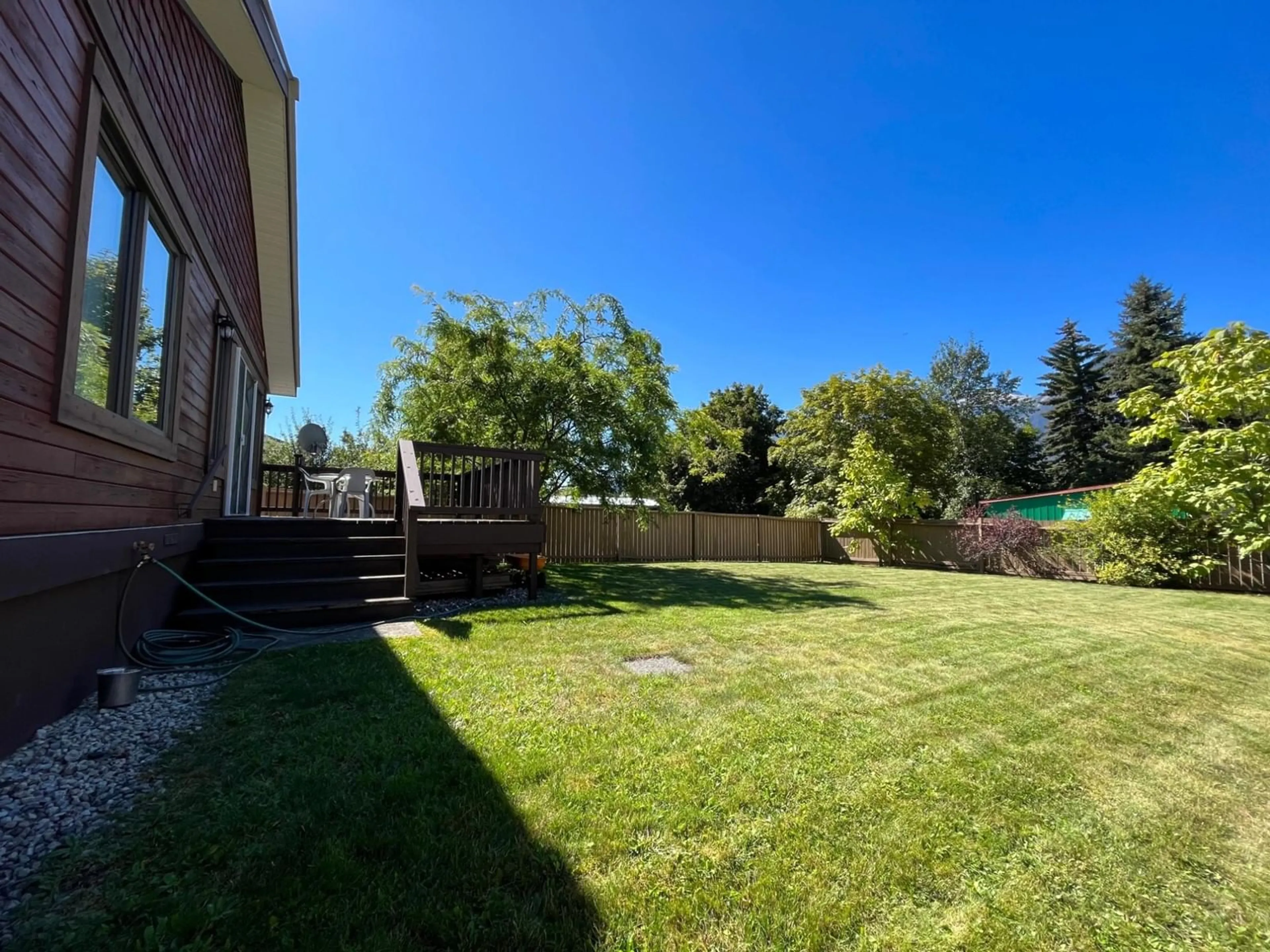 Frontside or backside of a home, the fenced backyard for 811 KILDARE Street, New Denver British Columbia V0G1S0