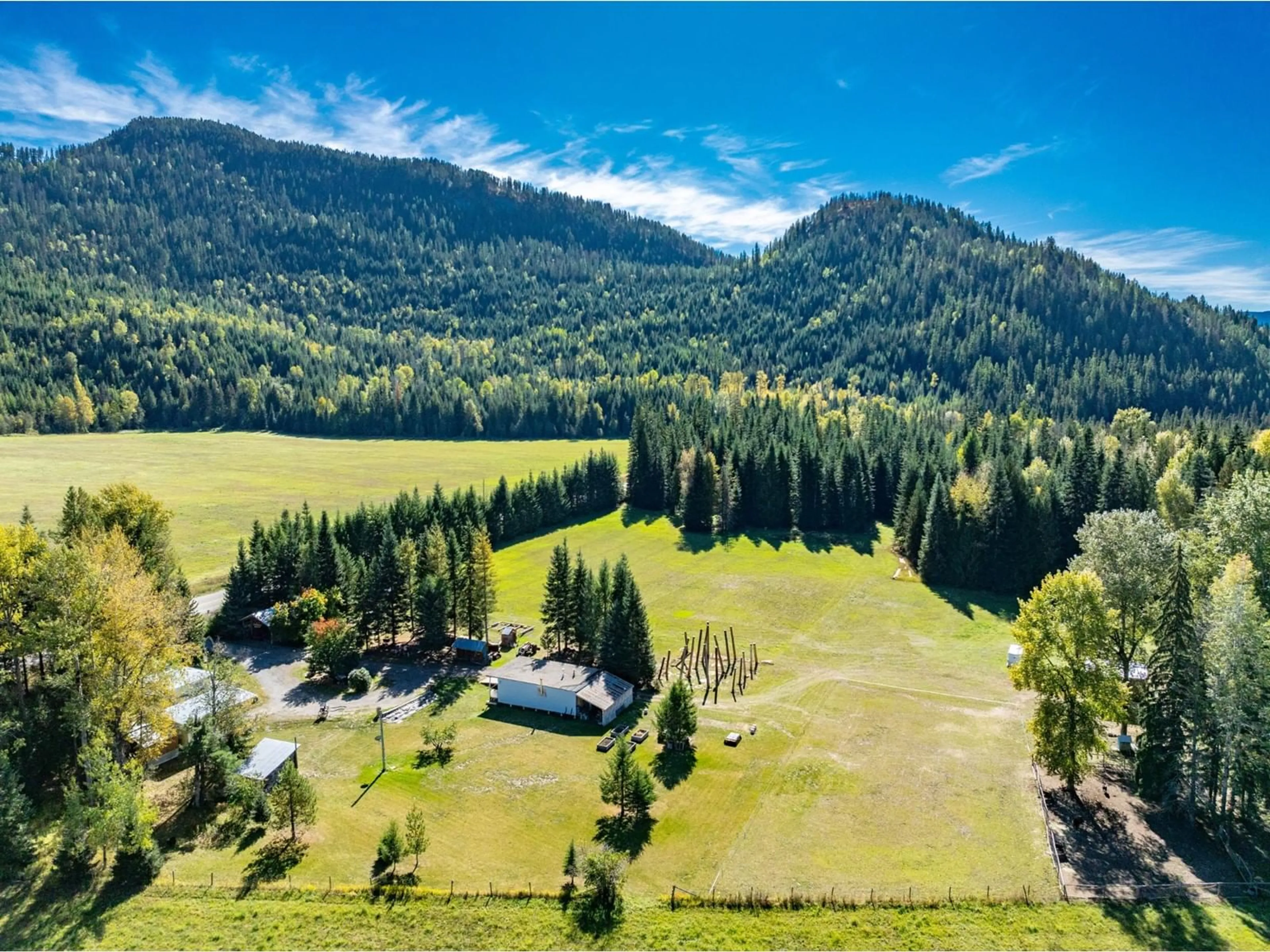 A pic from exterior of the house or condo, the fenced backyard for 9848 6 Highway, Salmo British Columbia V0G1Z0