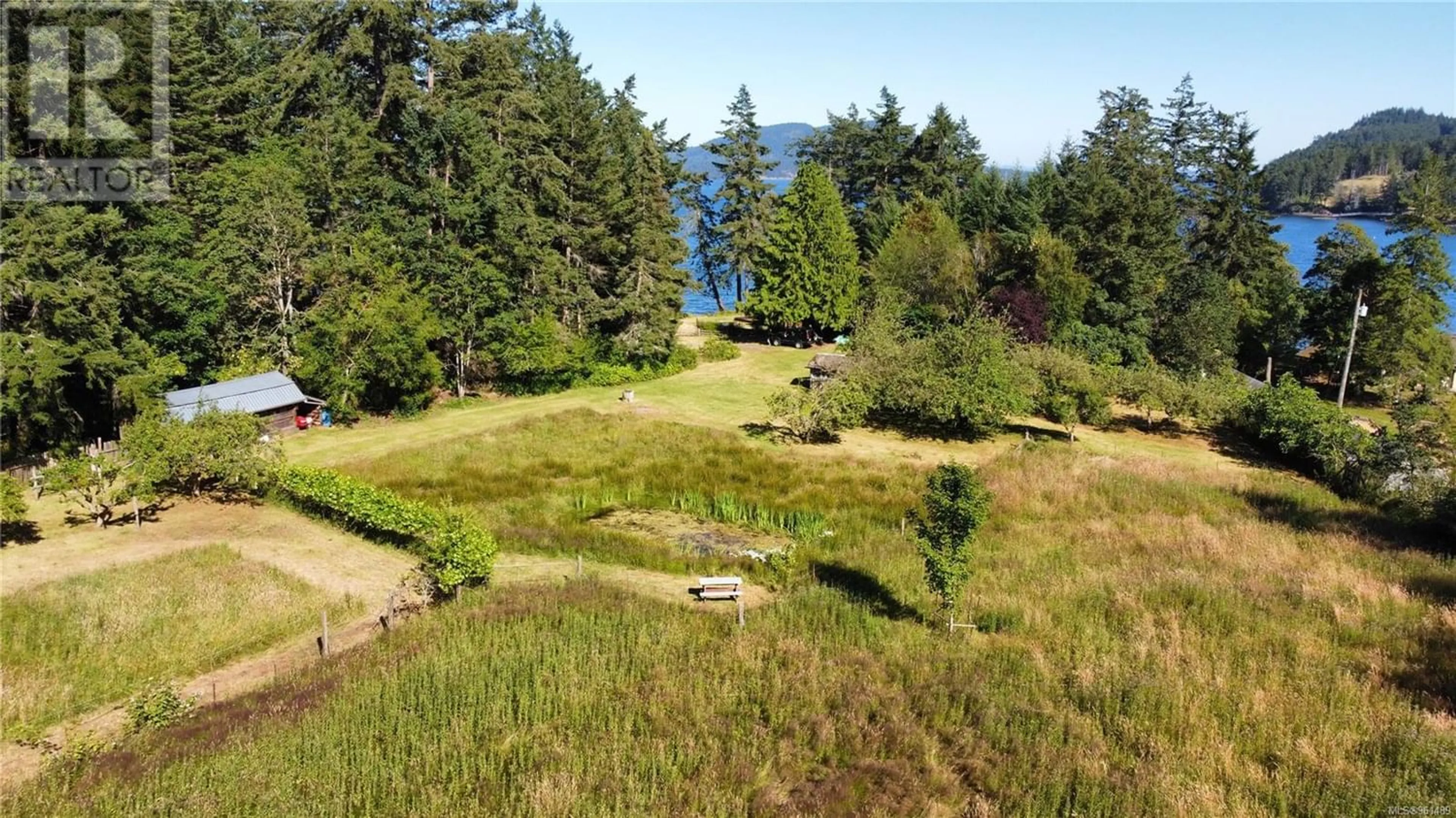 A pic from exterior of the house or condo, the fenced backyard for 4312 Clam Bay Rd, Pender Island British Columbia V0N2M1