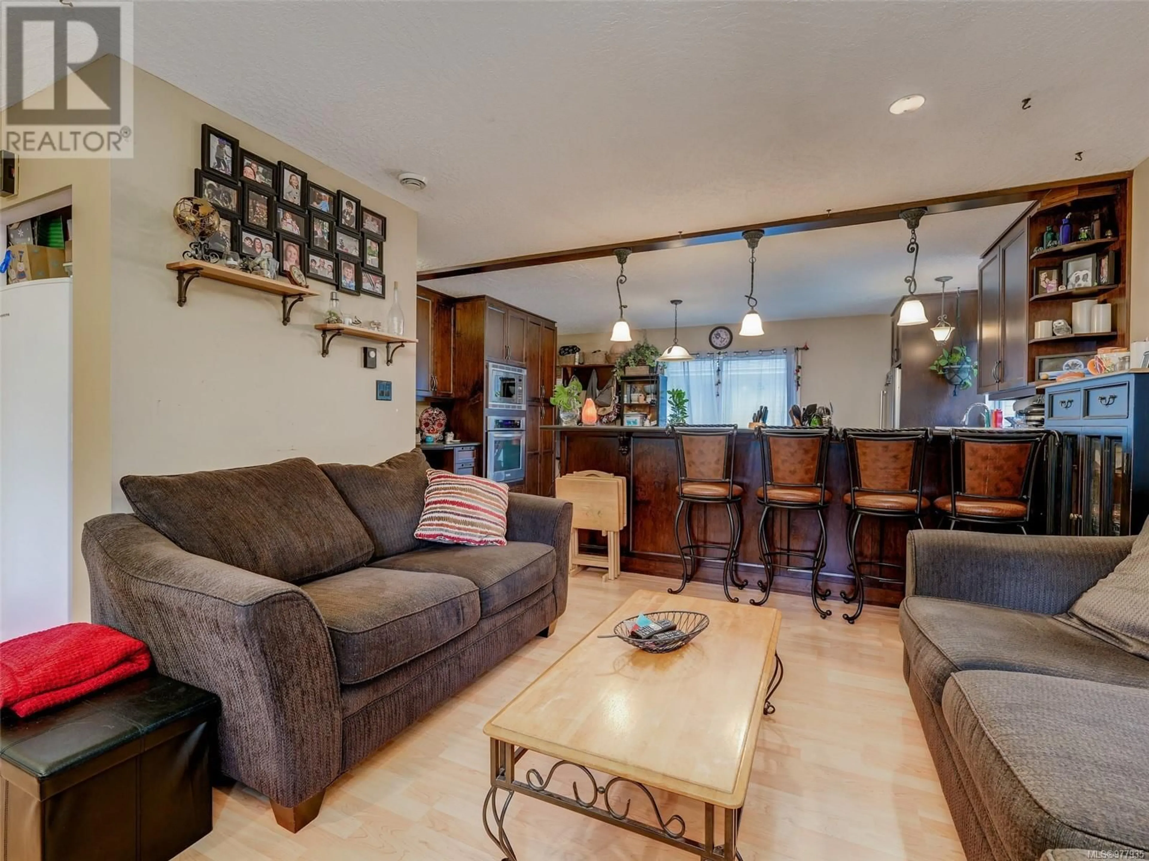 Living room with furniture, wood/laminate floor for 7045 Brooks Pl, Sooke British Columbia V9Z0P8