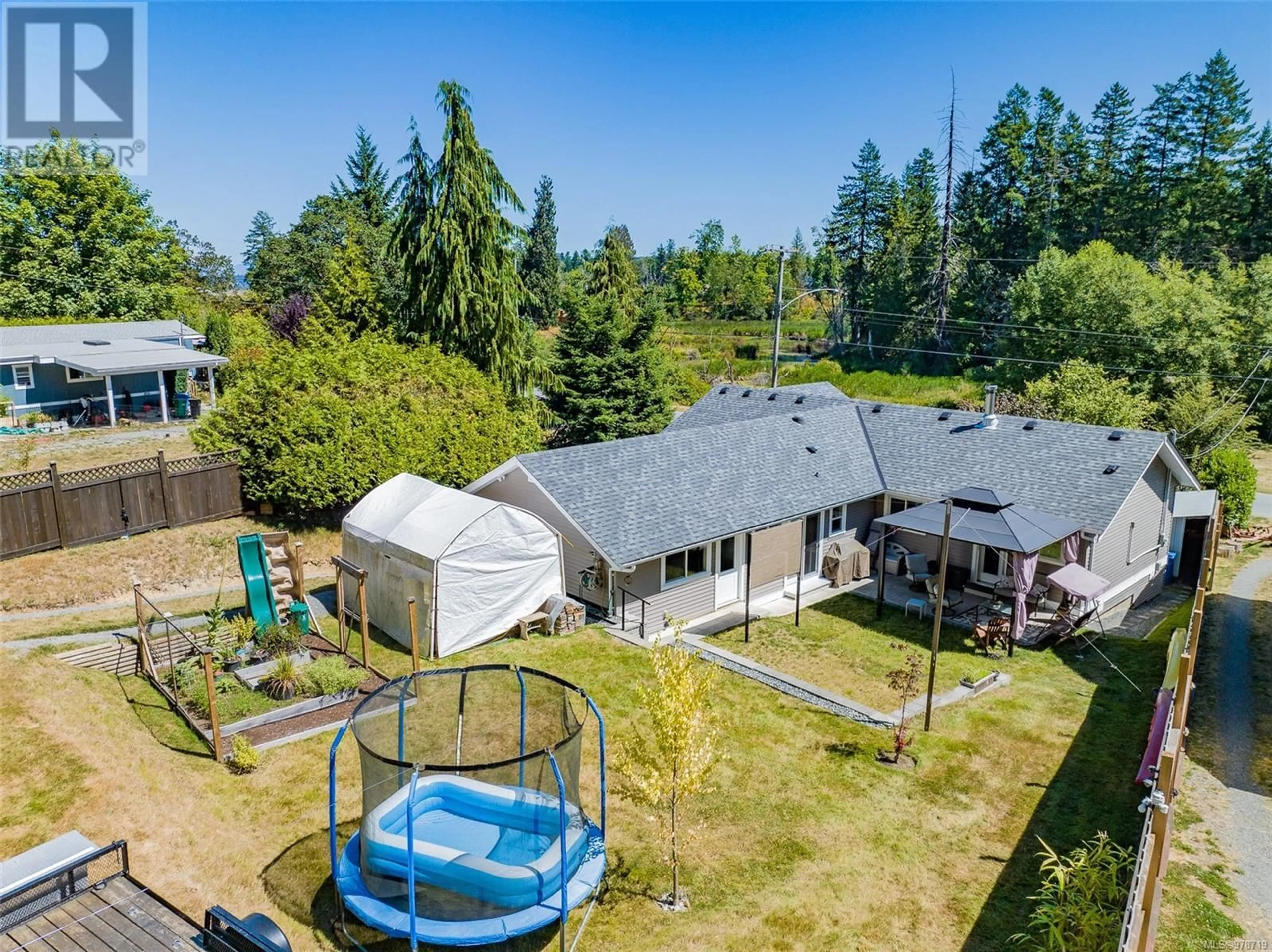 Frontside or backside of a home, the fenced backyard for 1357 Fielding Rd, Nanaimo British Columbia V9X1K8