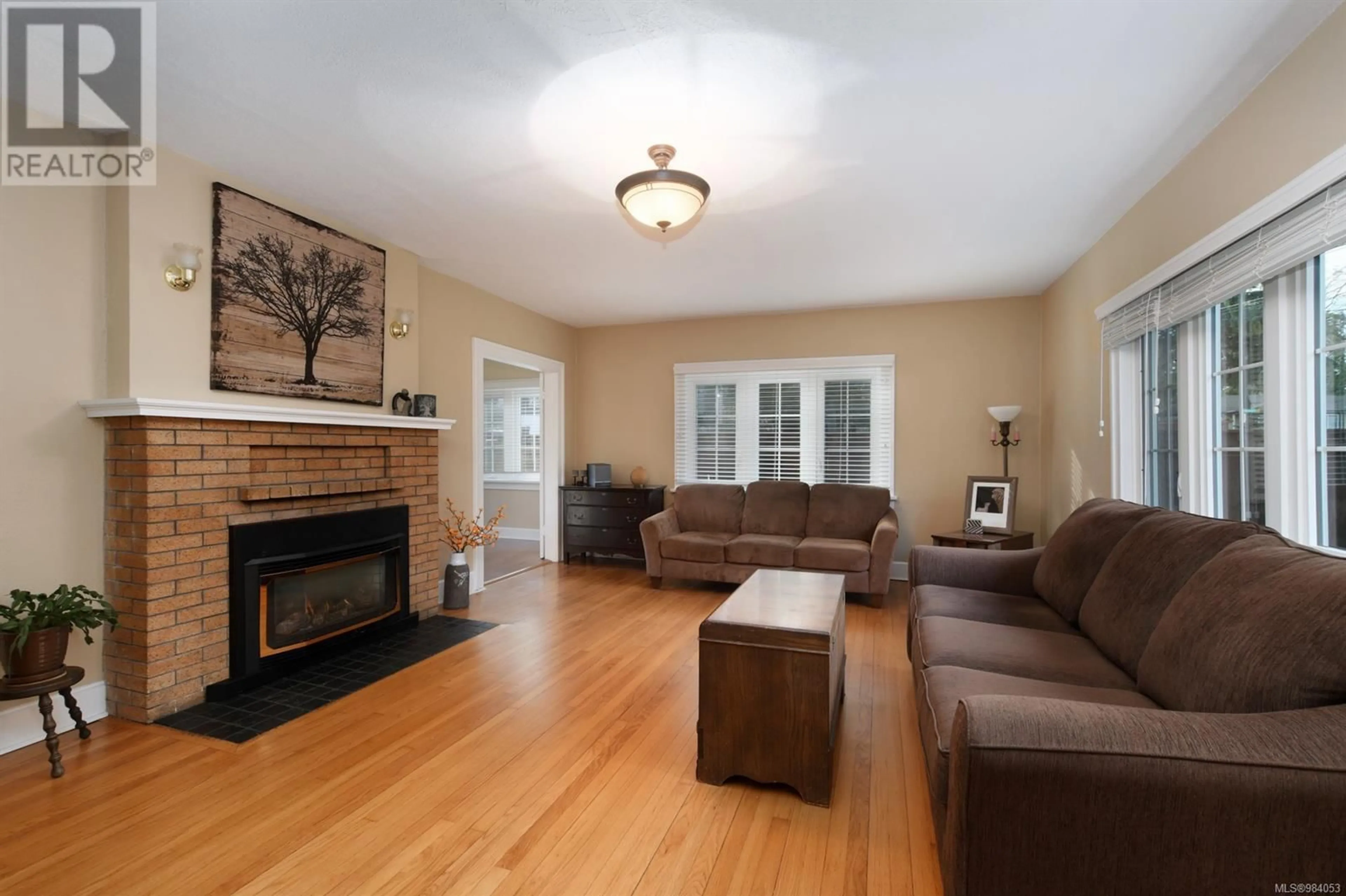 Living room with furniture, wood/laminate floor for 3919 Quadra St, Saanich British Columbia V8X1J3