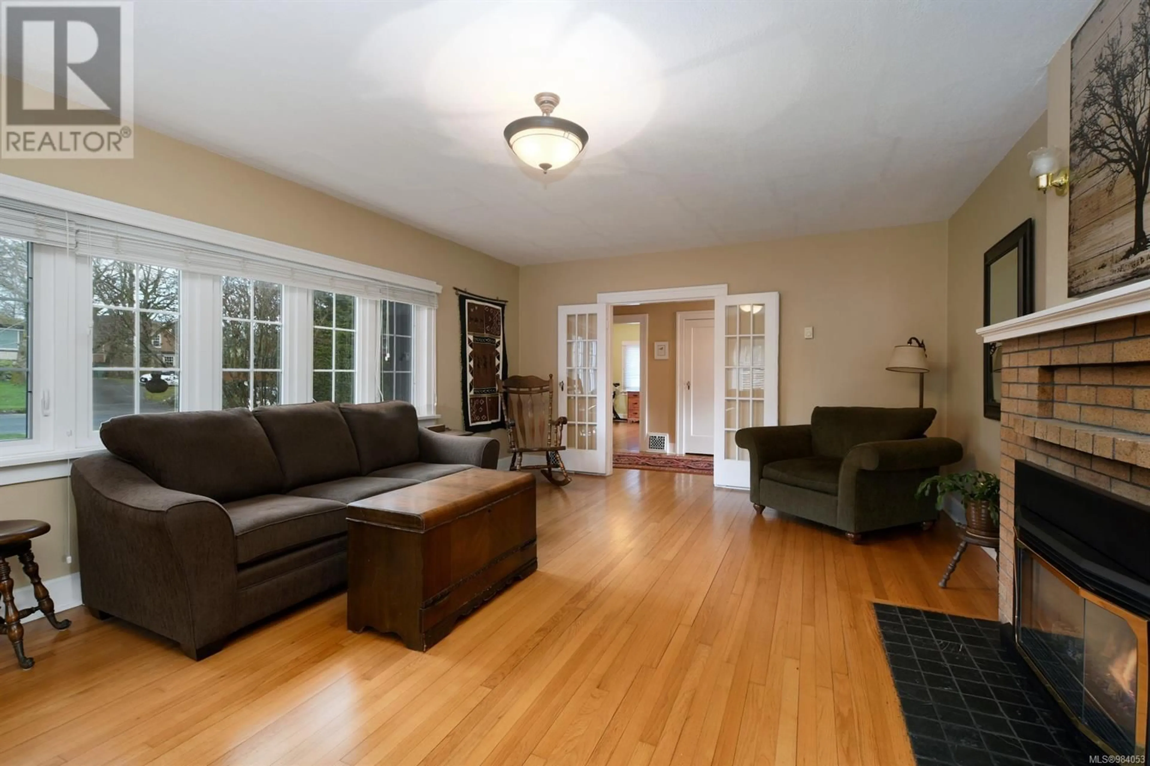 Living room with furniture, wood/laminate floor for 3919 Quadra St, Saanich British Columbia V8X1J3