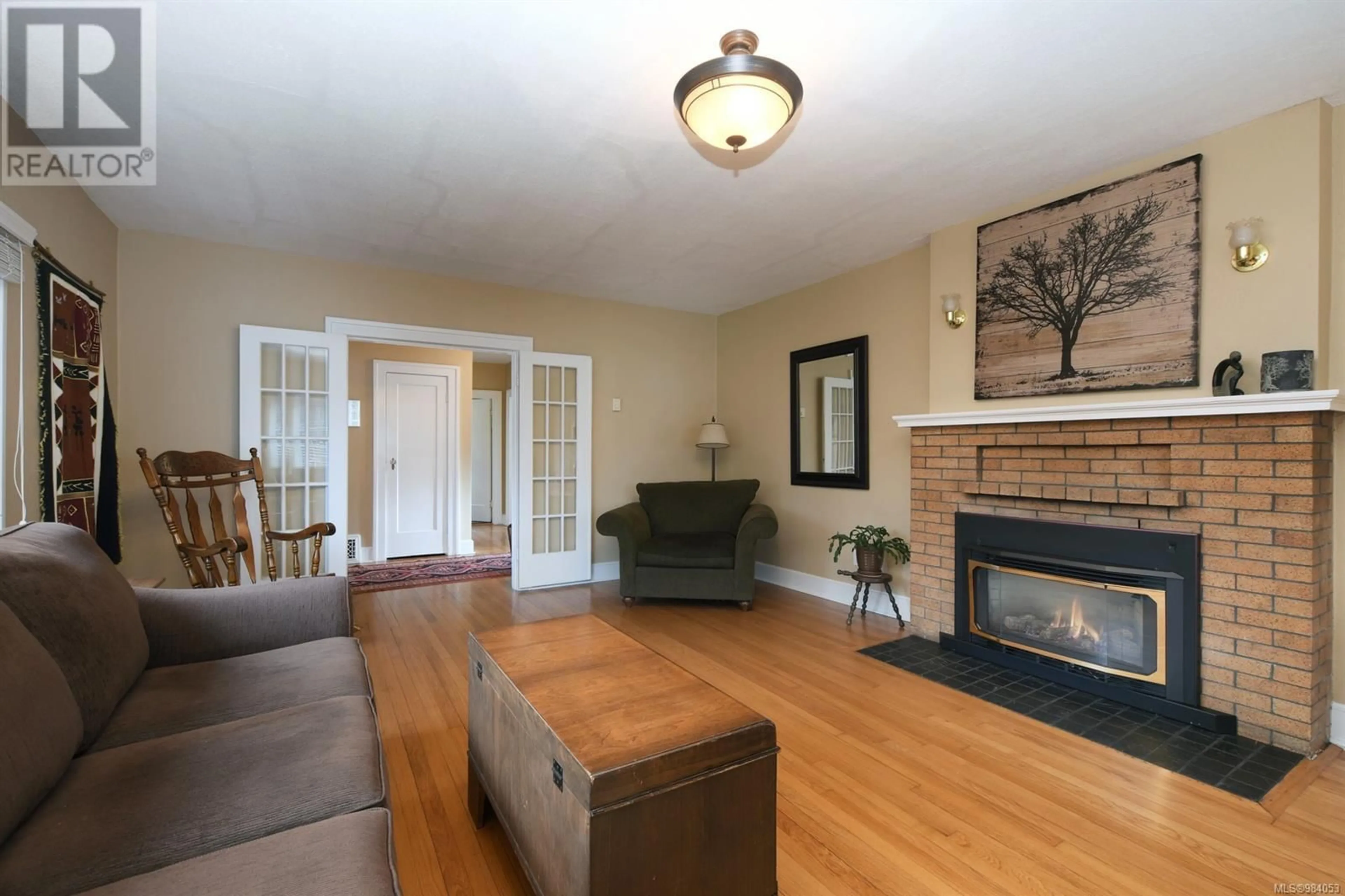 Living room with furniture, wood/laminate floor for 3919 Quadra St, Saanich British Columbia V8X1J3