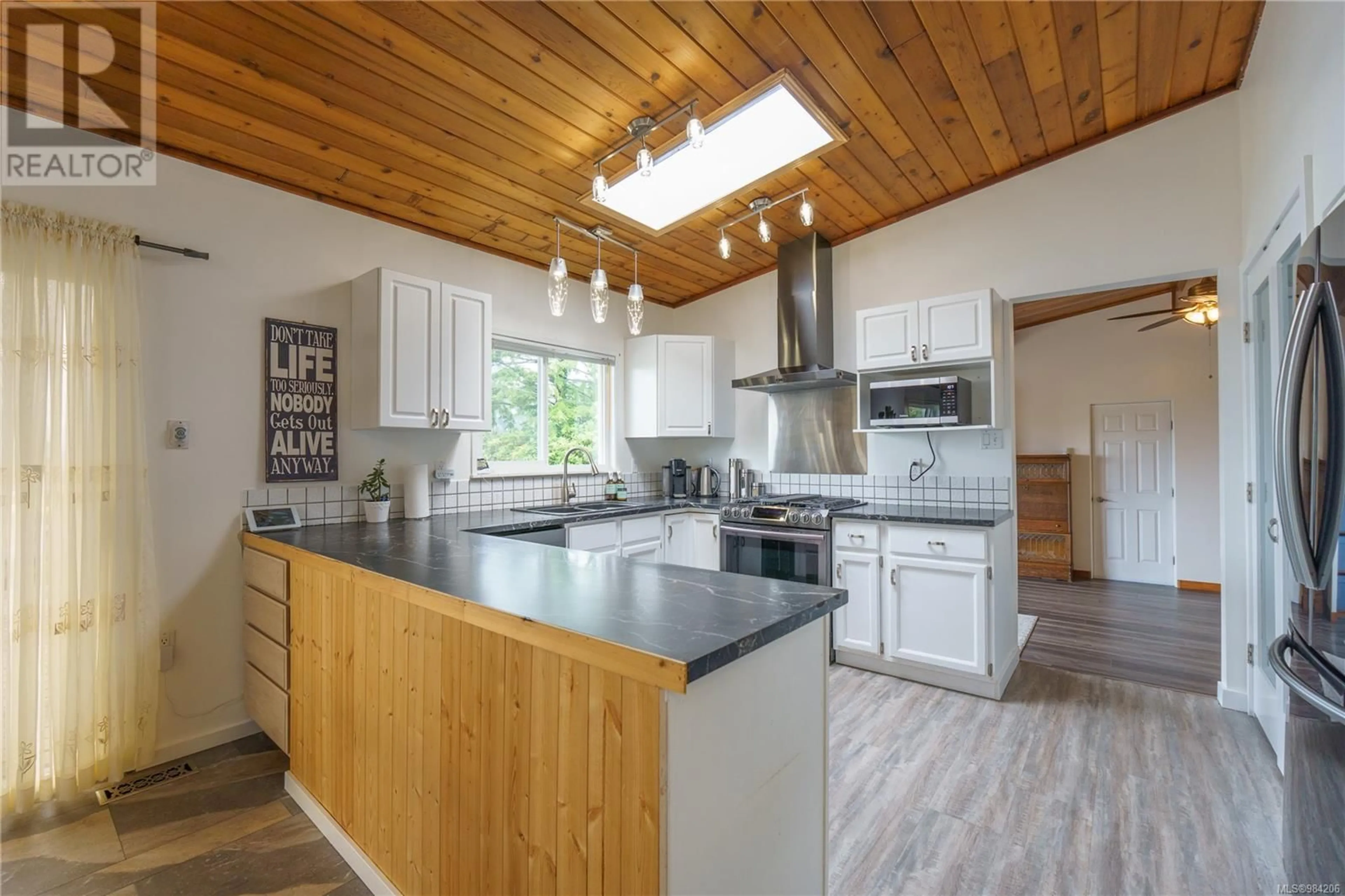 Open concept kitchen, wood/laminate floor for 204 Birch St, Ucluelet British Columbia V0R3A0