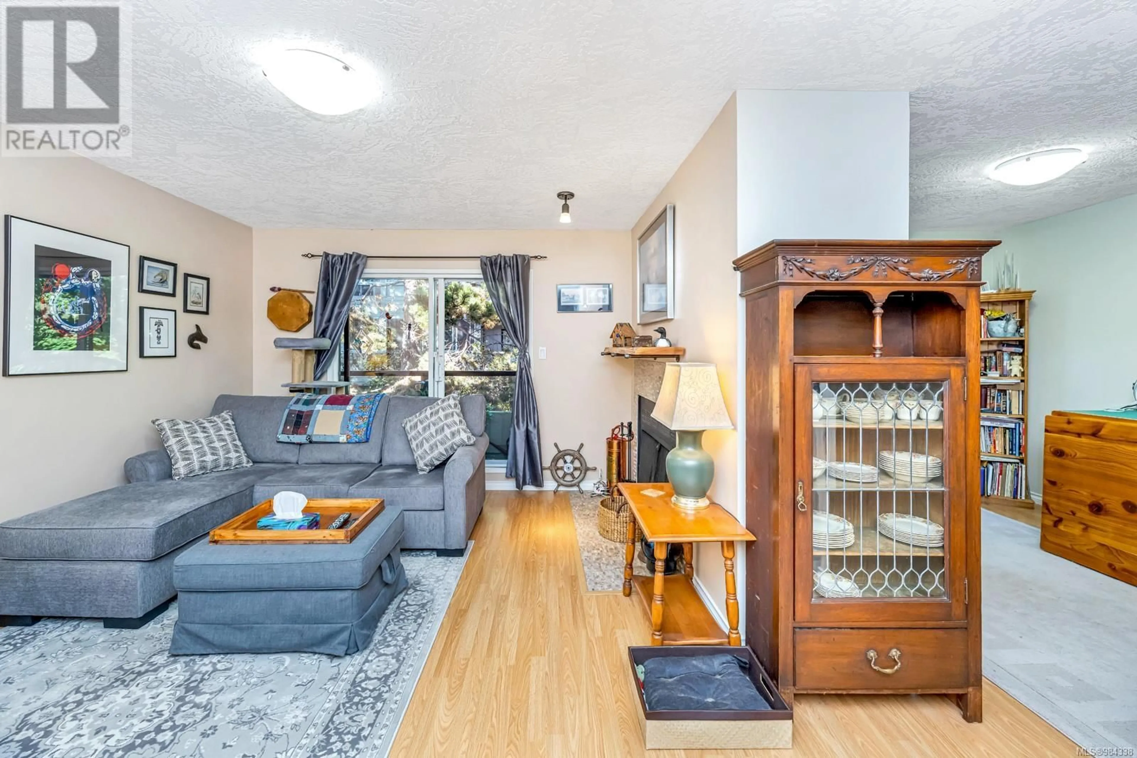 Living room with furniture, wood/laminate floor for 203 940 Inverness Rd, Saanich British Columbia V8X2R9