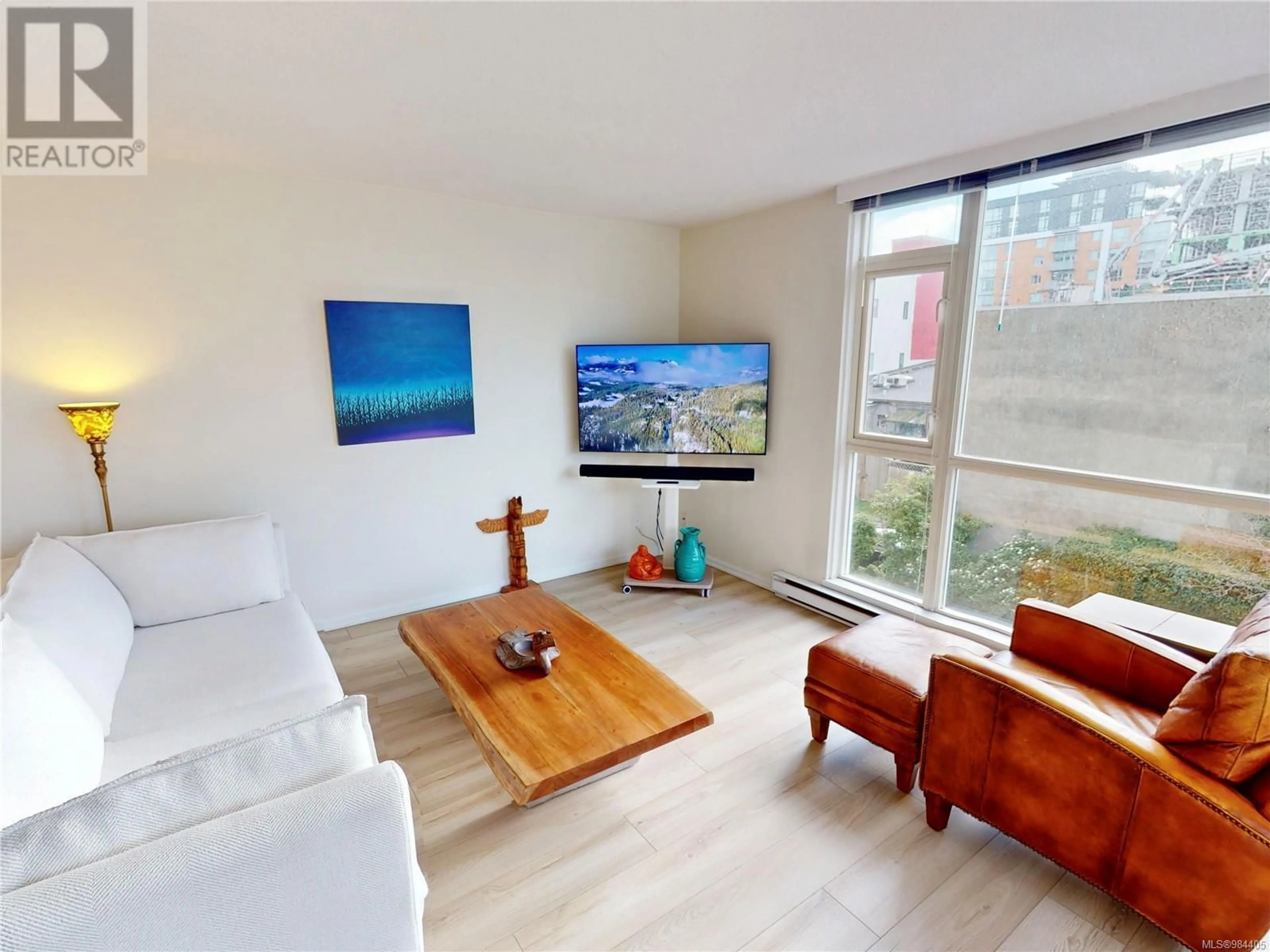 Living room with furniture, wood/laminate floor for 312 835 View St, Victoria British Columbia V8W3W8