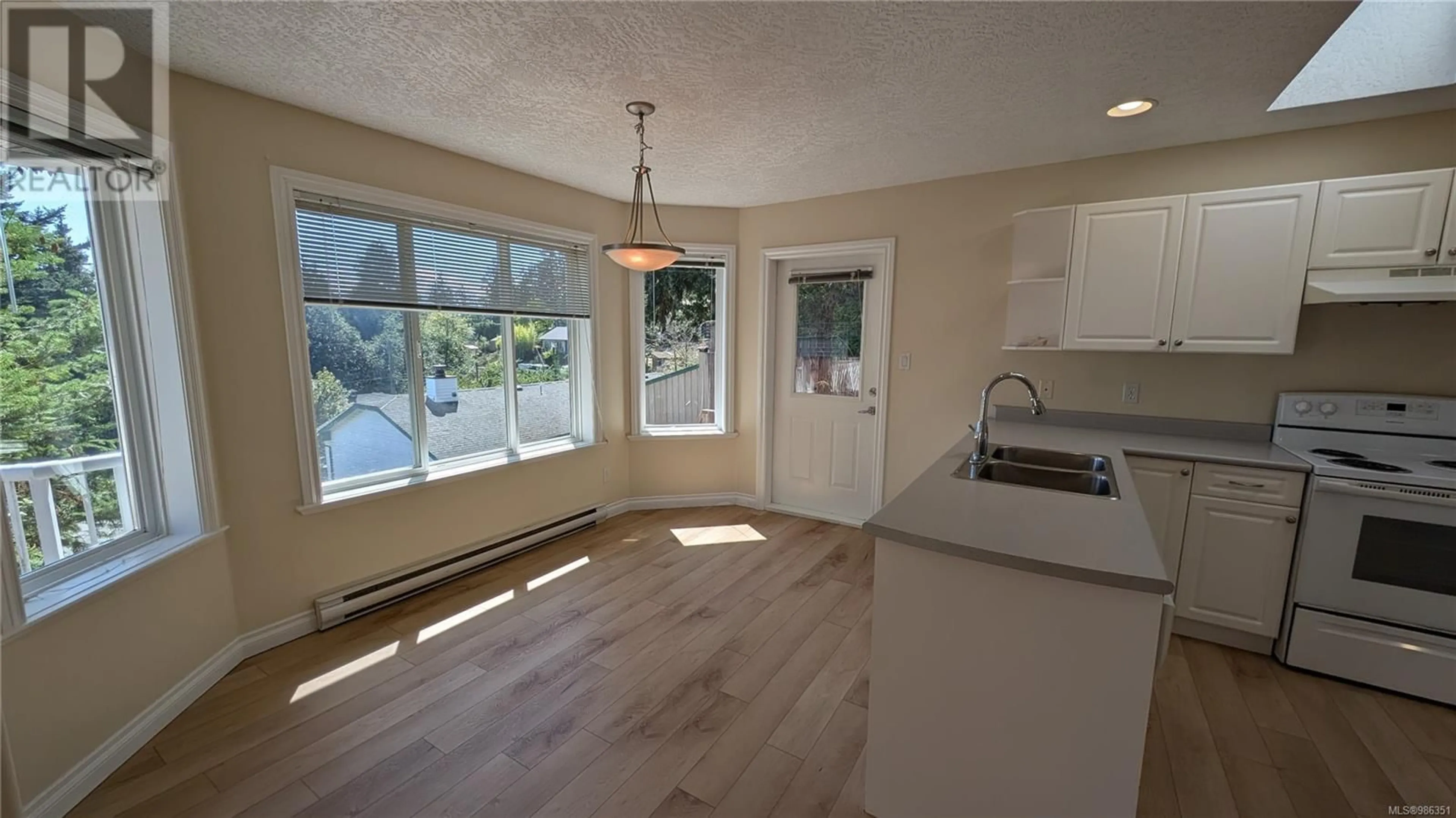 Open concept kitchen, wood/laminate floor for 7074/7076 Maple Park Terr, Sooke British Columbia V9Z0N2