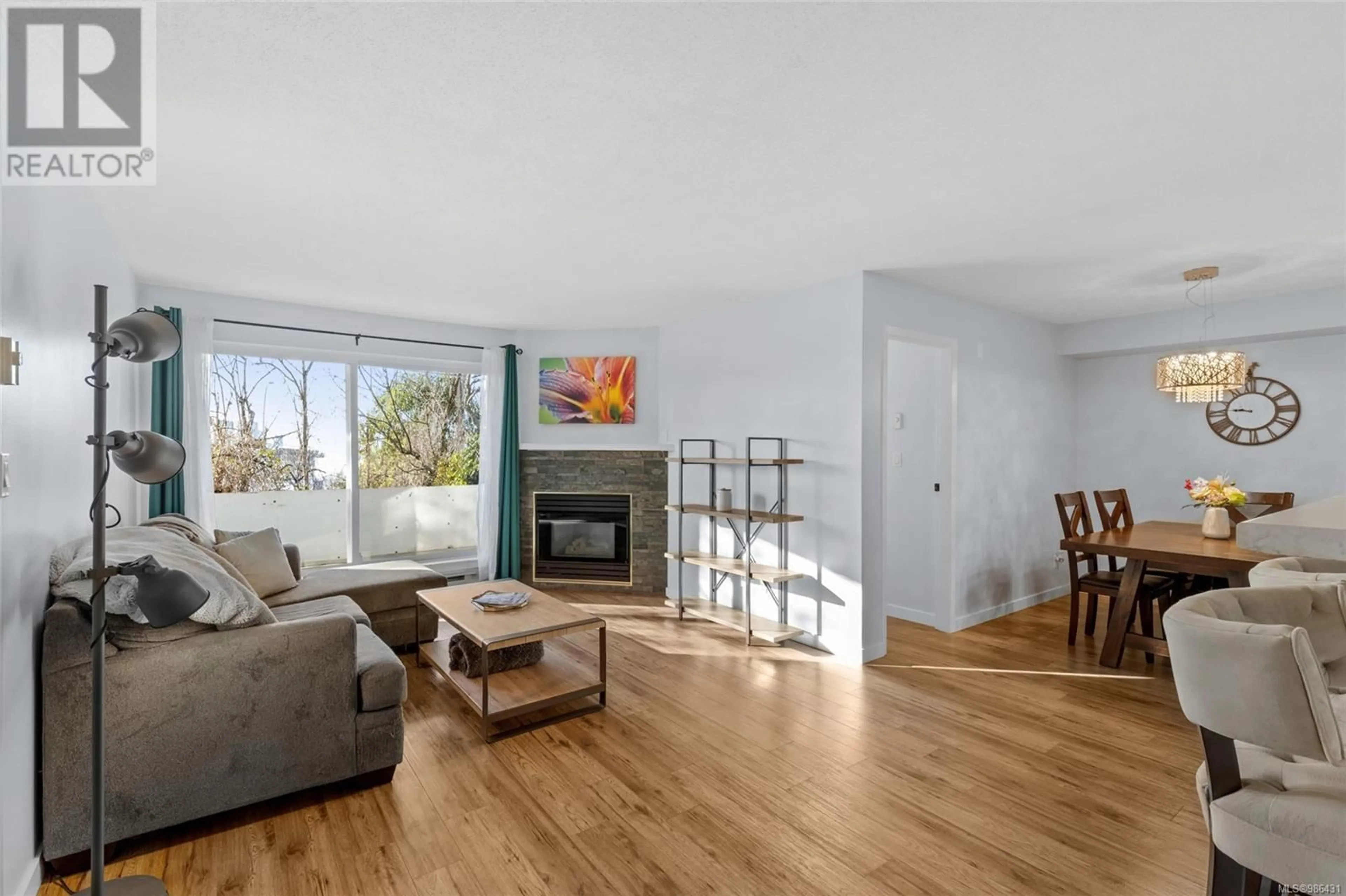 Living room with furniture, wood/laminate floor for 112 3206 Alder St, Saanich British Columbia V8X1P2