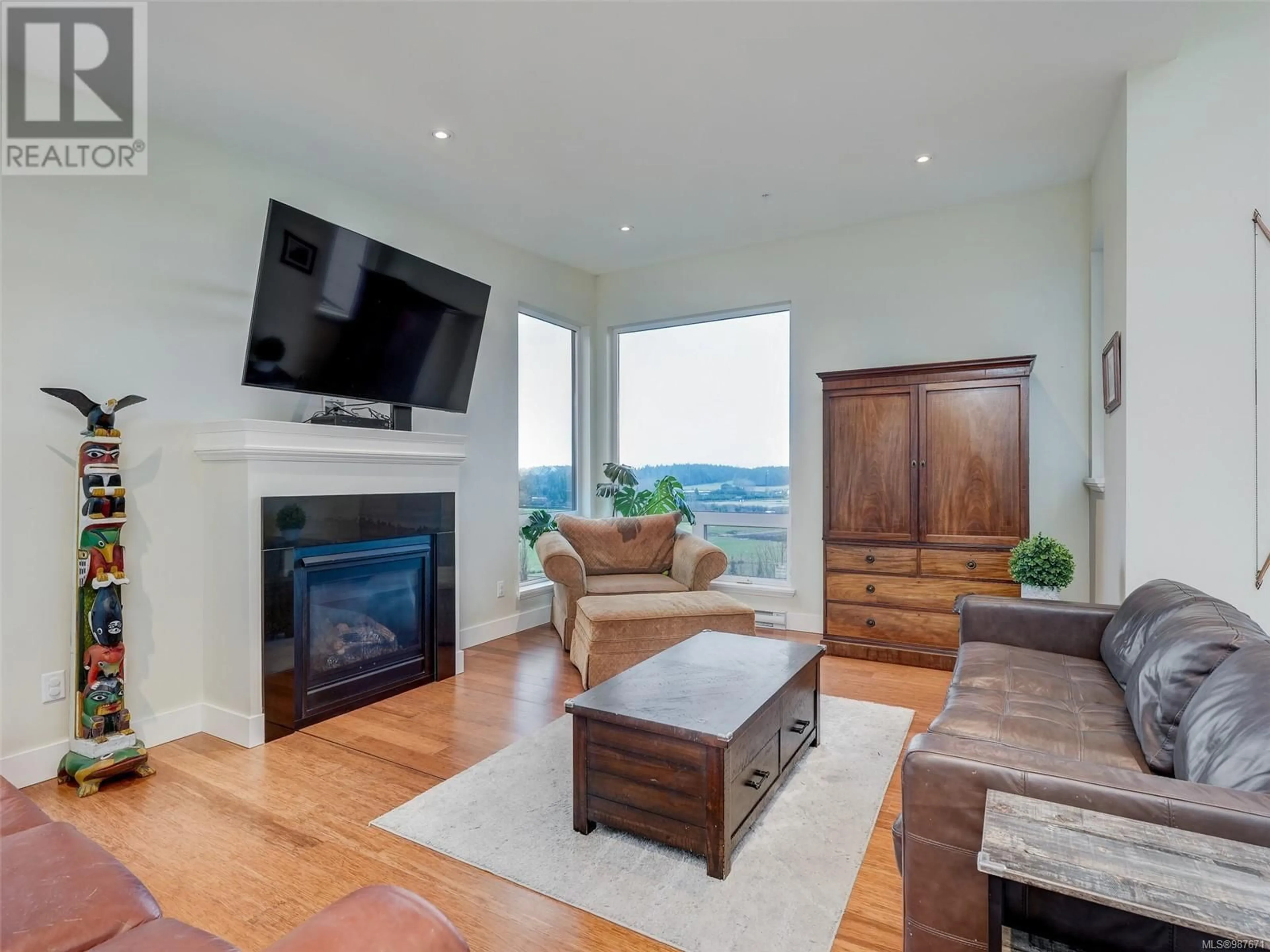 Living room with furniture, wood/laminate floor for 302 6981 East Saanich Rd, Central Saanich British Columbia V8Z5Z2