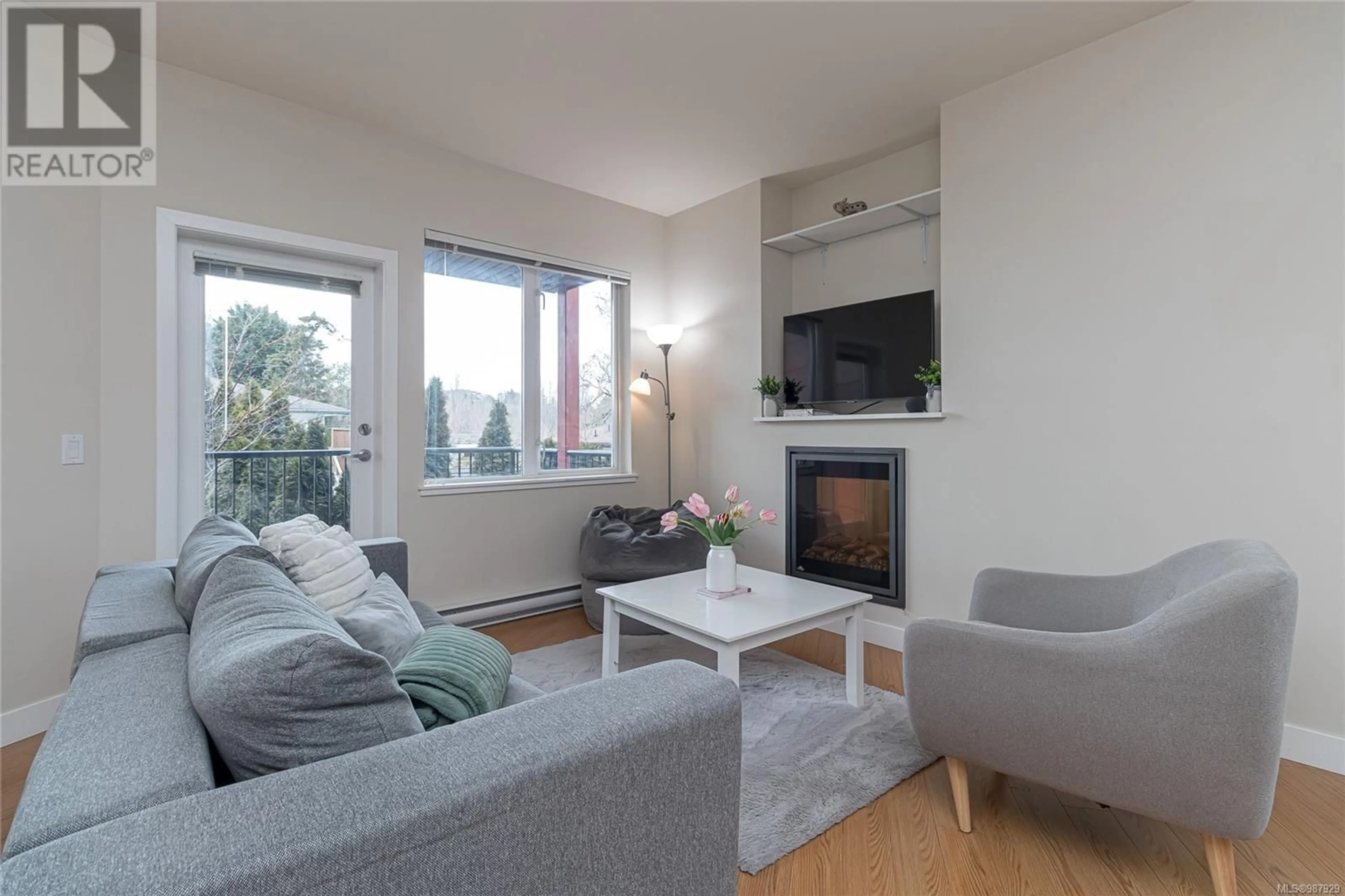 Living room with furniture, wood/laminate floor for 204 4040 Borden St, Saanich British Columbia V8X2E9