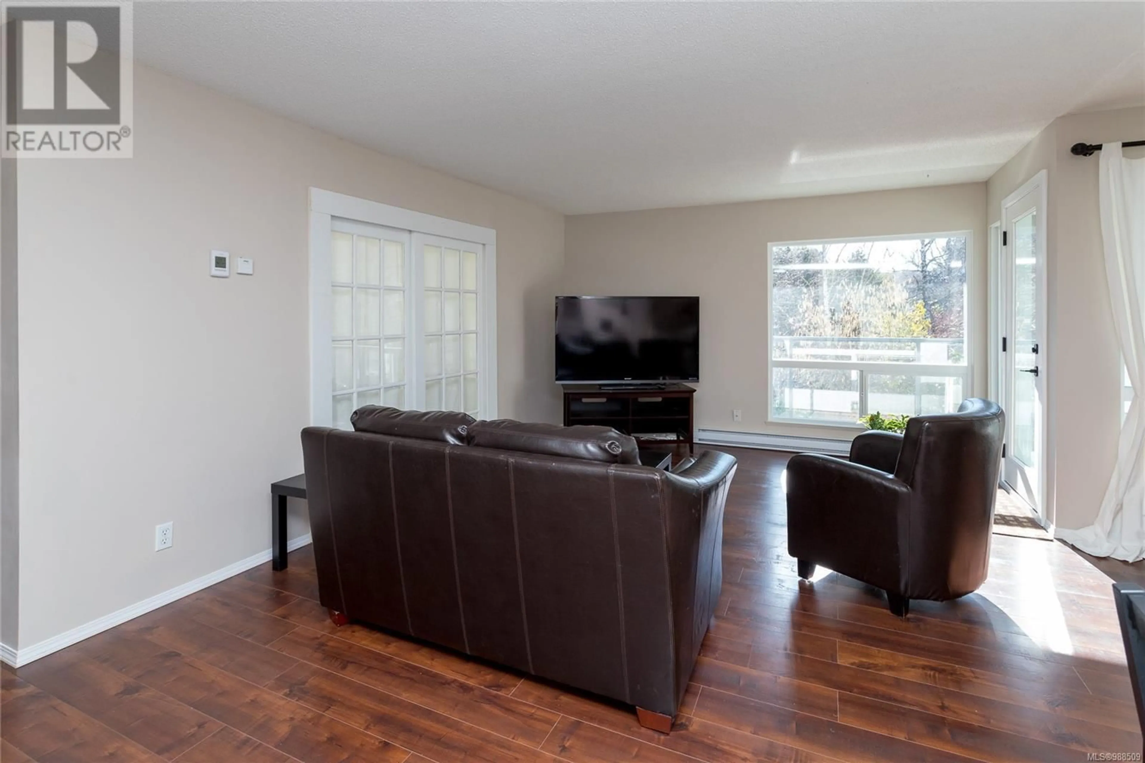 Living room with furniture, wood/laminate floor for 207 1725 Cedar Hill Cross Rd, Saanich British Columbia V8P2P8