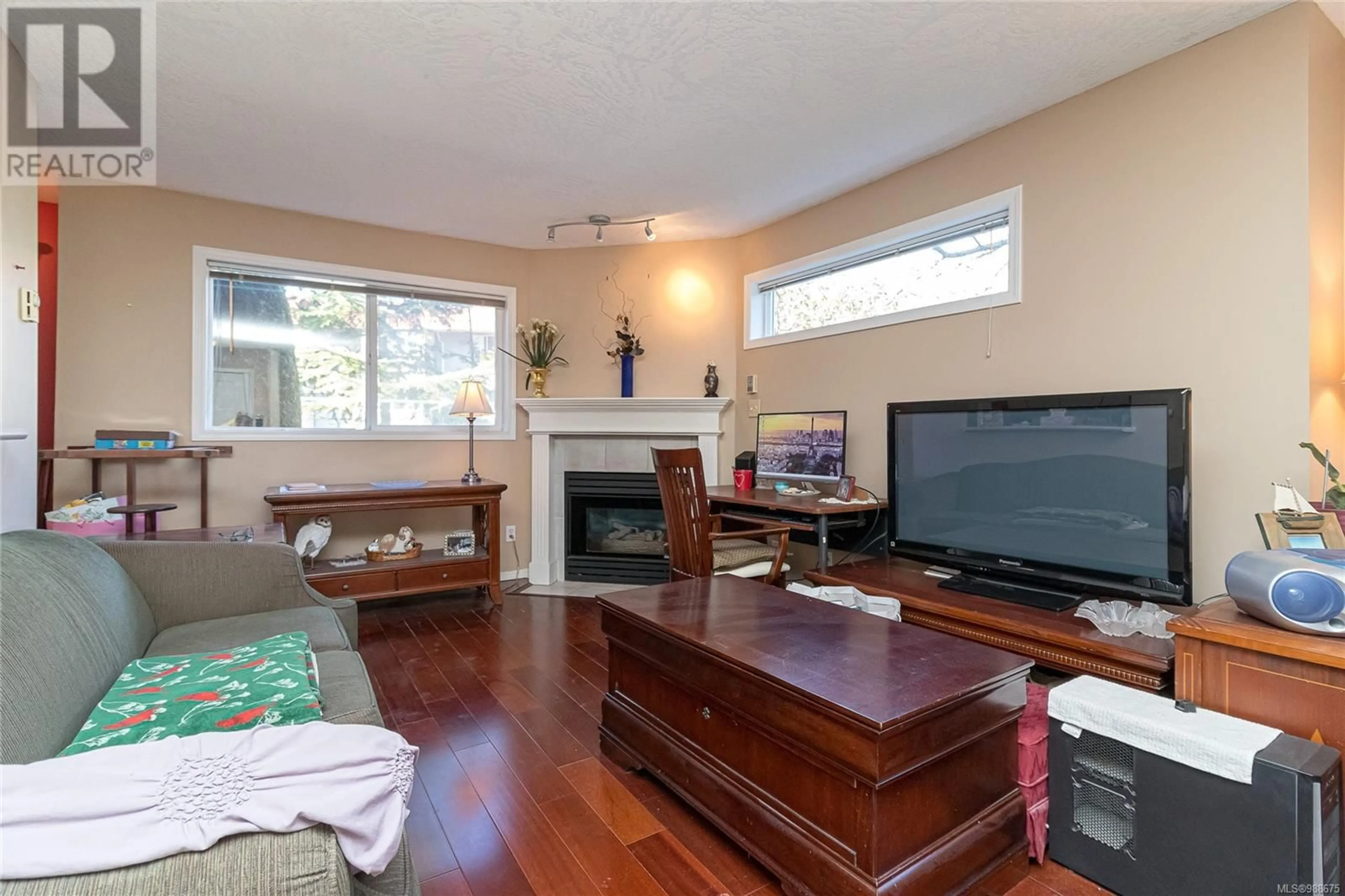 Living room with furniture, wood/laminate floor for 101 894 Vernon Ave, Saanich British Columbia V8X2W6