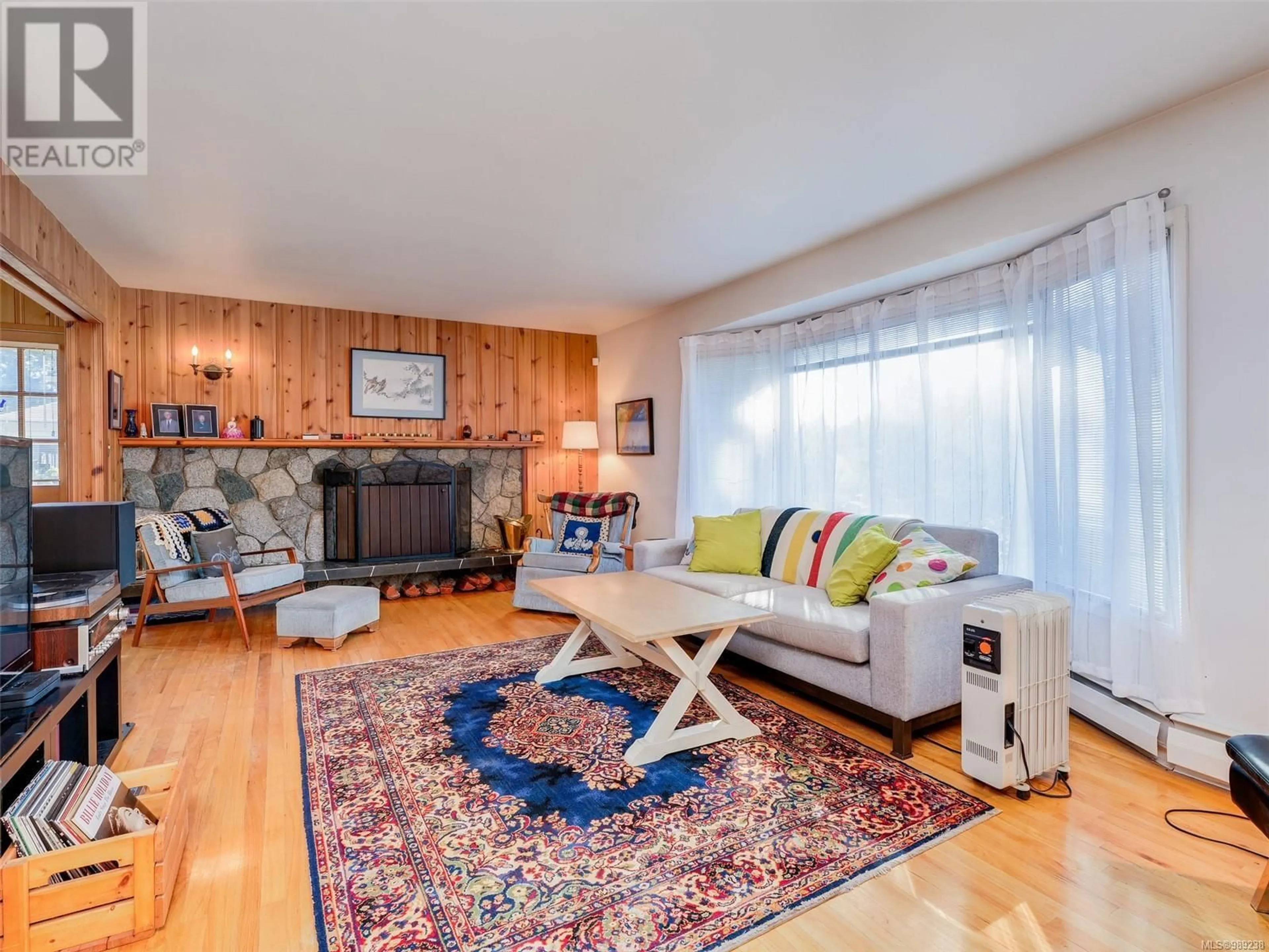 Living room with furniture, wood/laminate floor for 4799 Cordova Bay Rd, Saanich British Columbia V8Y2J8