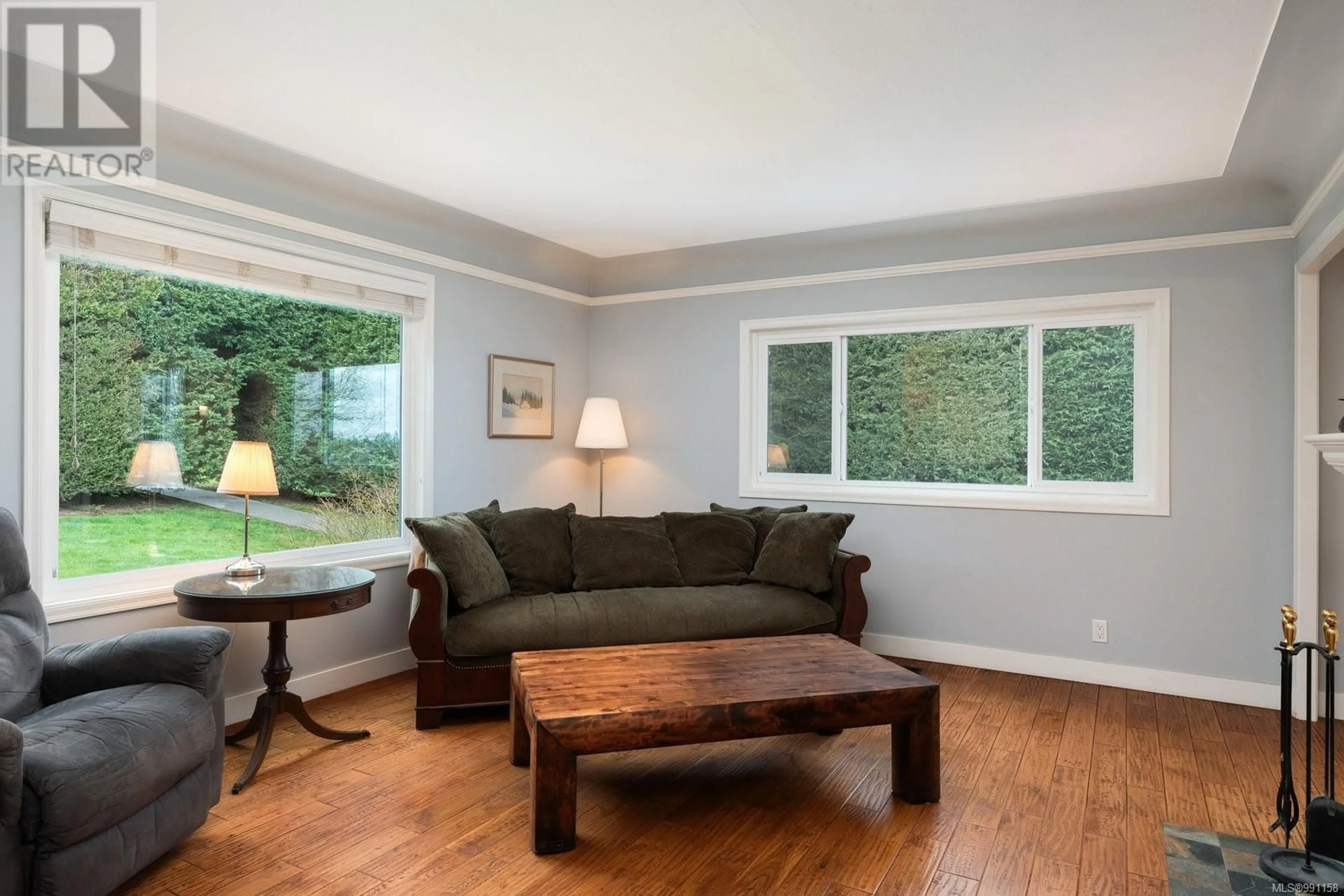 Living room with furniture, wood/laminate floor for 6435 Oldfield Rd, Central Saanich British Columbia V8M1X8