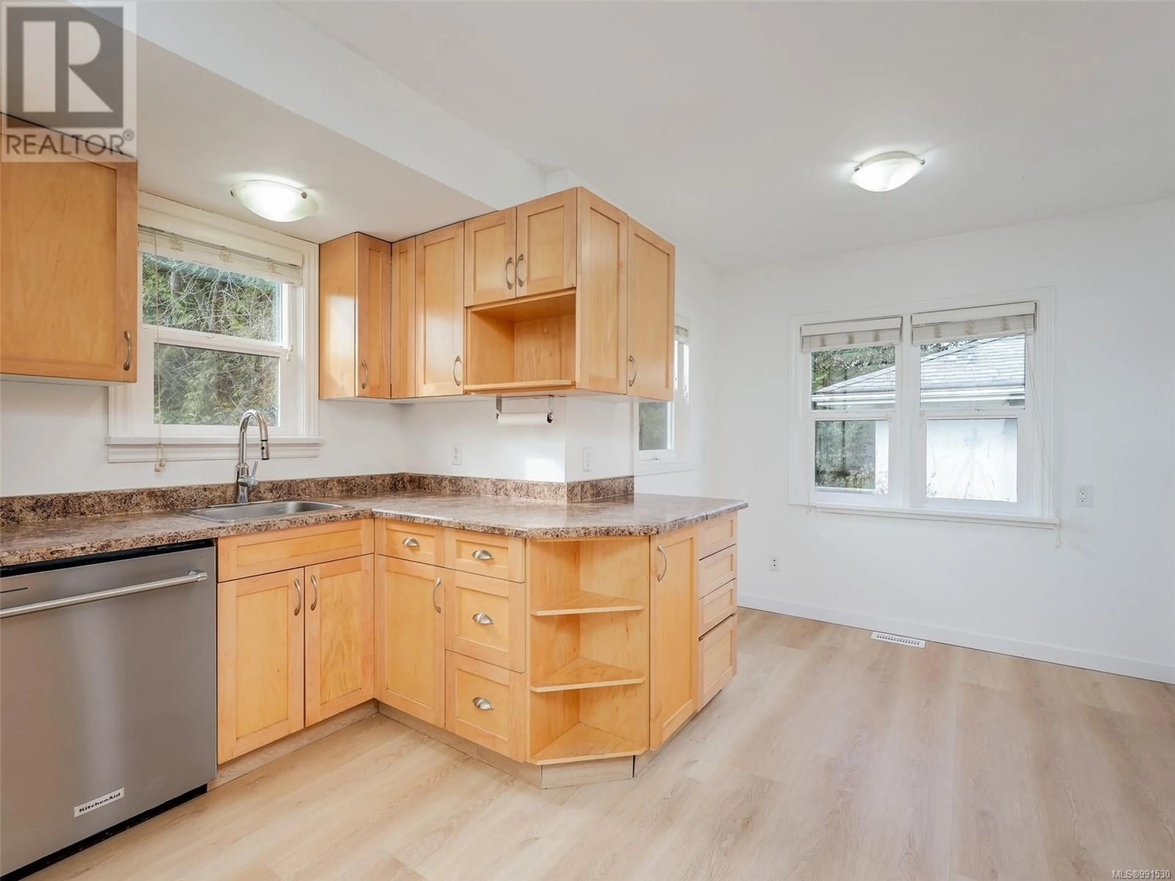 Open concept kitchen, wood/laminate floor for 1621 McRae Ave, Saanich British Columbia V8P1G7