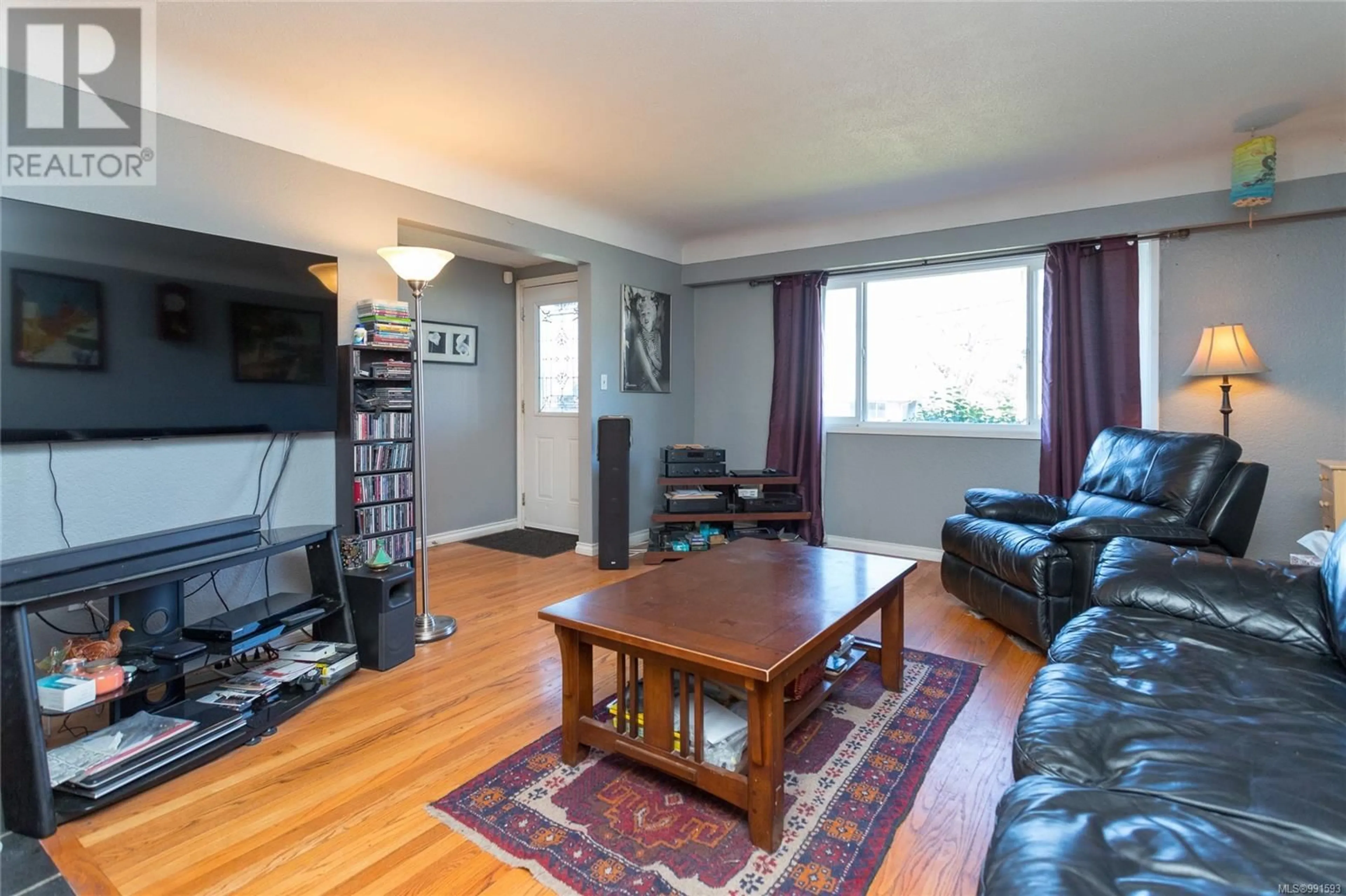 Living room with furniture, wood/laminate floor for 723 Lily Ave, Saanich British Columbia V8X3R7