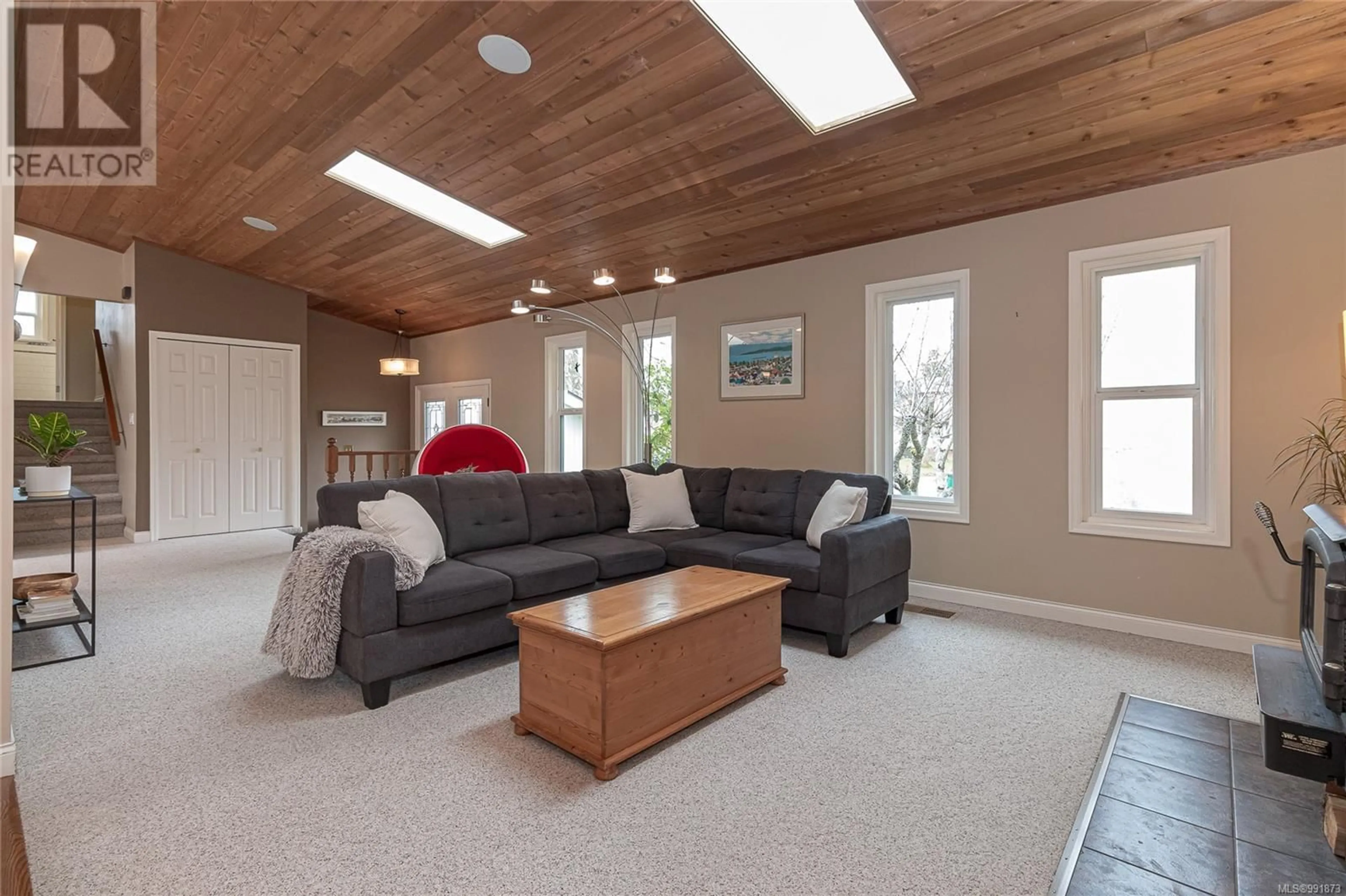 Living room with furniture, wood/laminate floor for 4022 Cavallin Crt, Saanich British Columbia V8N5P9