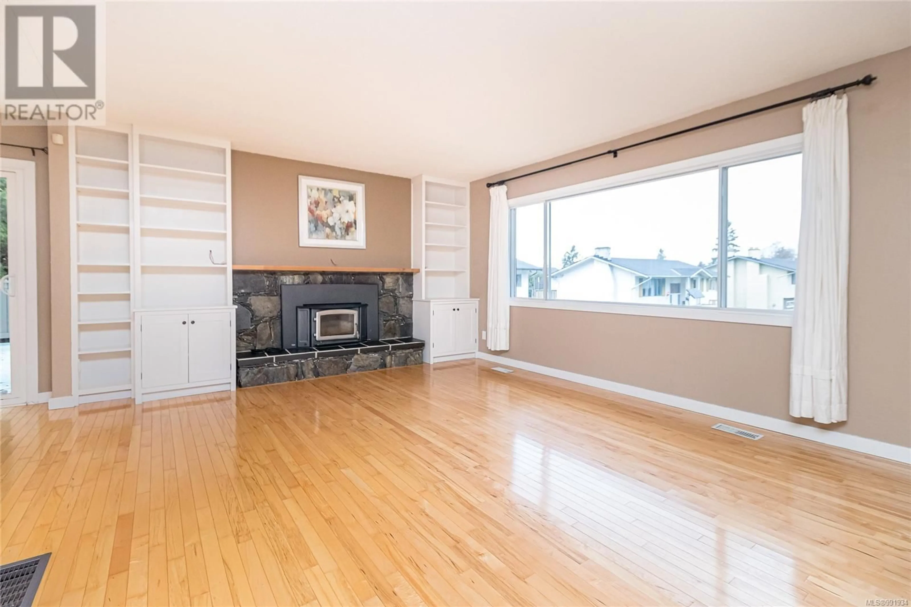 Living room with furniture, wood/laminate floor for 1667 Bisley Pl, Saanich British Columbia V8N4M6