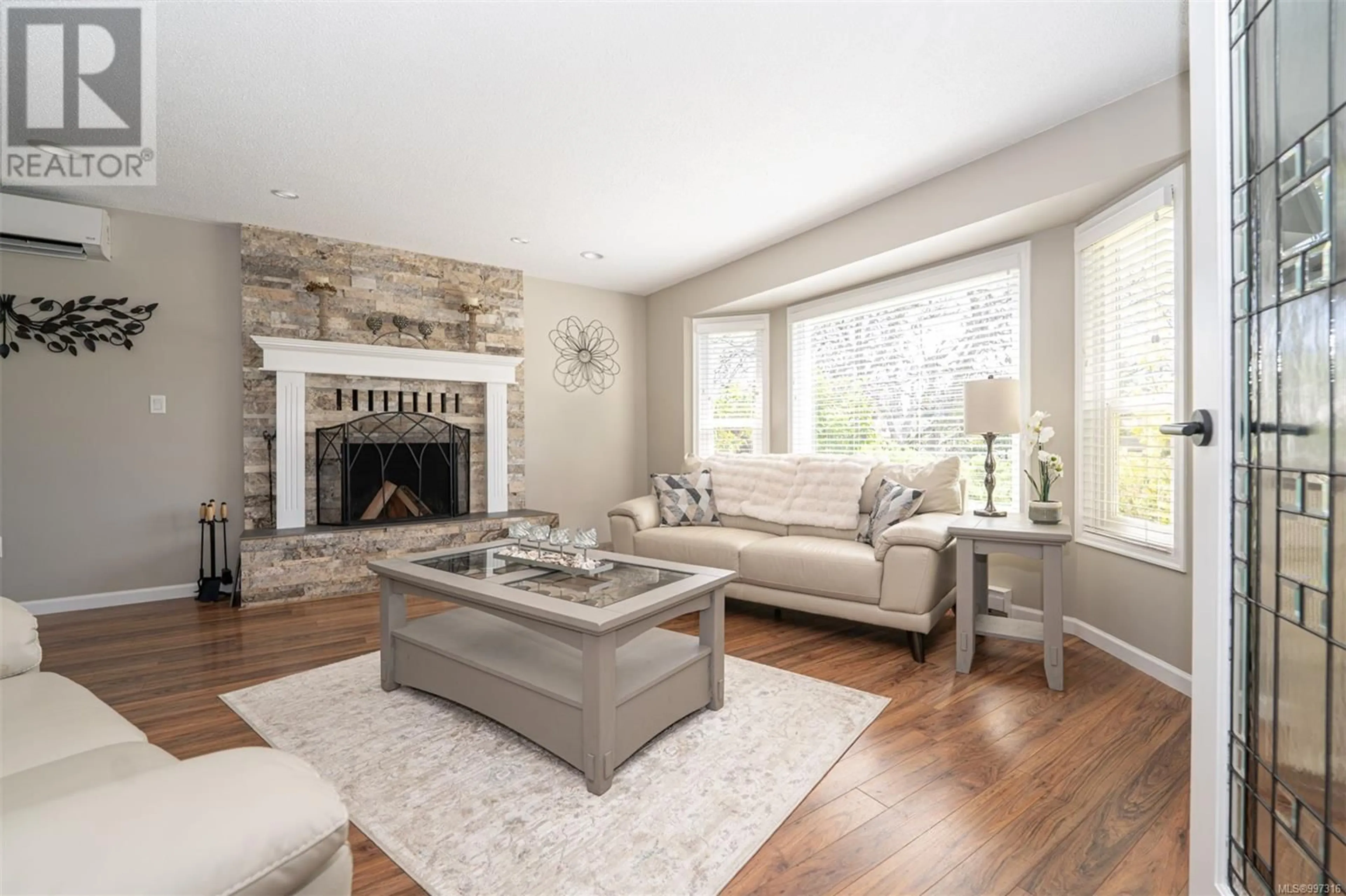 Living room with furniture, wood/laminate floor for 1126 DAMELART WAY, Central Saanich British Columbia V8M1E3