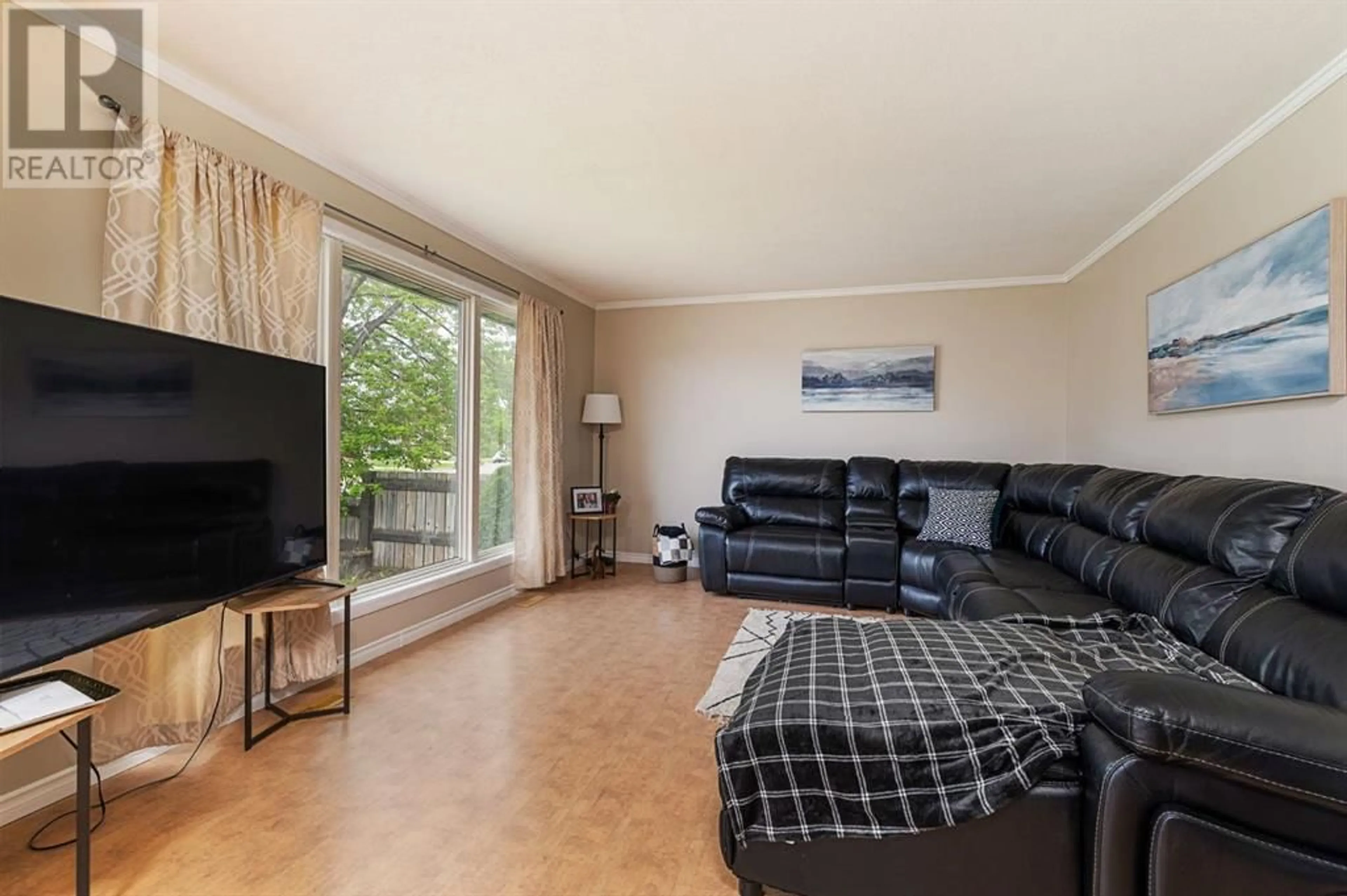 Living room with furniture, wood/laminate floor for 2312 47 AVENUE, Lloydminster Alberta S9V1L3