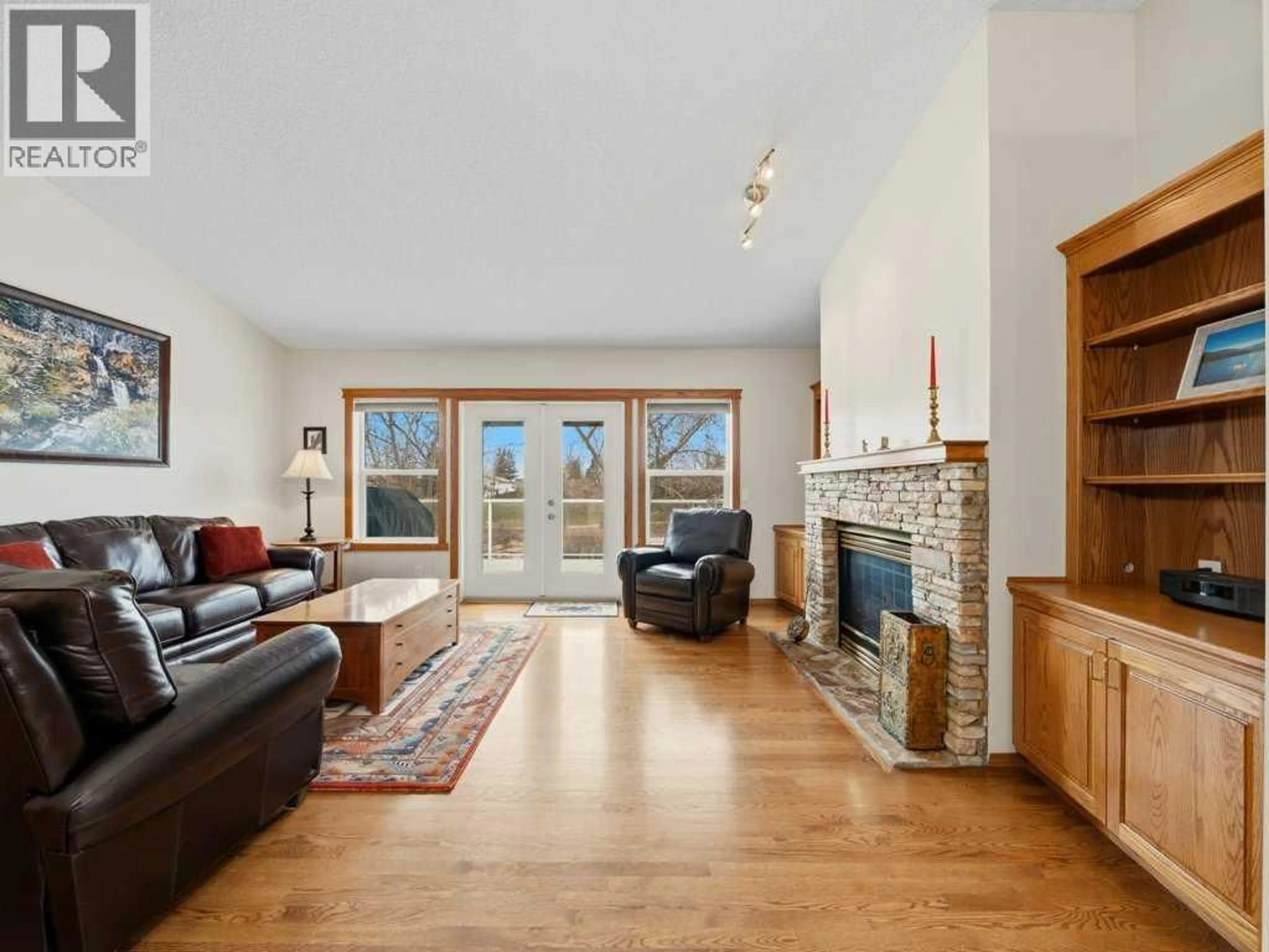 Living room with furniture, wood/laminate floor for 152 WATERSTONE PLACE SOUTHEAST, Airdrie Alberta T4B2G1