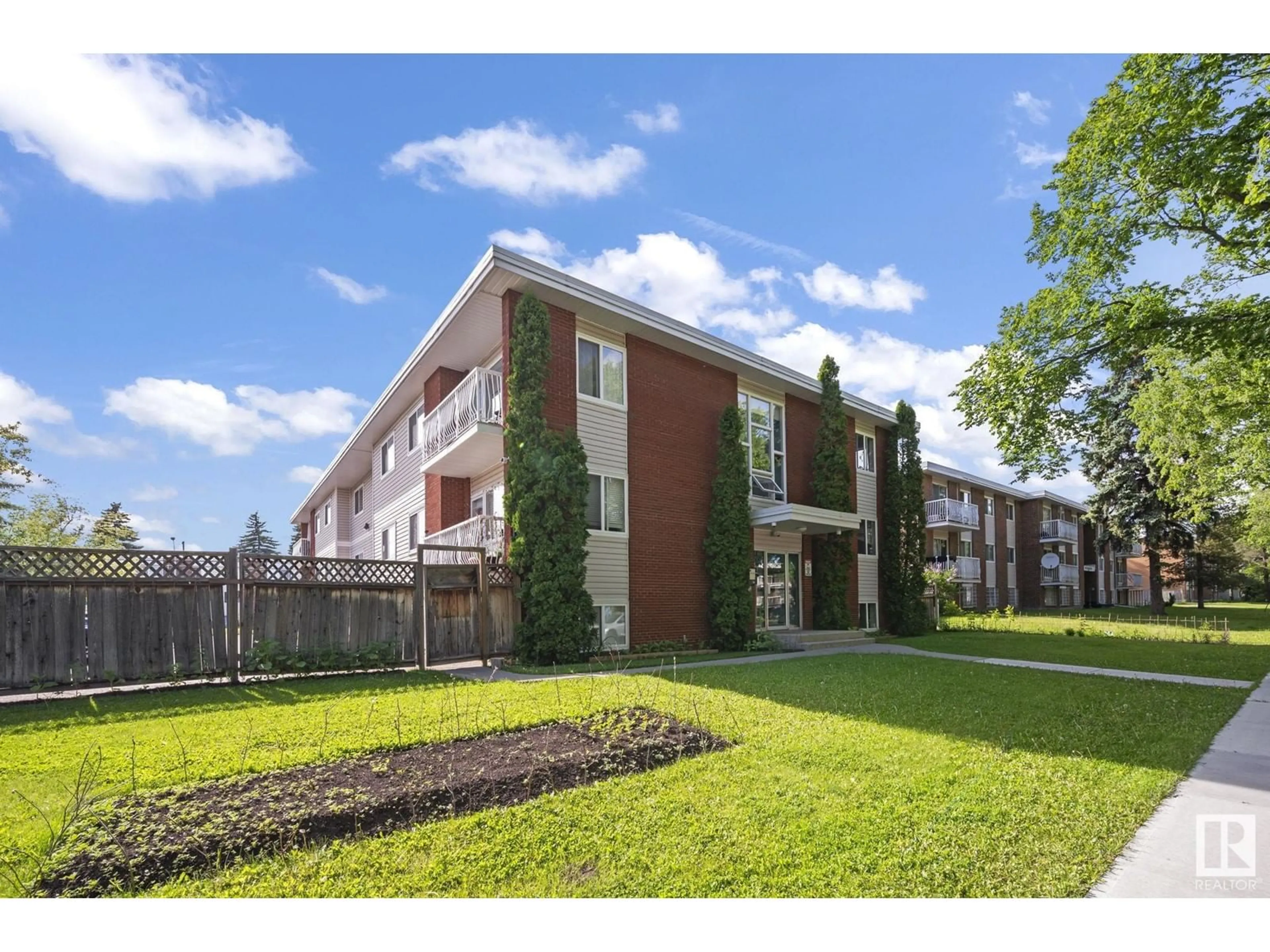 A pic from exterior of the house or condo, the fenced backyard for #1 10812 115 ST NW, Edmonton Alberta T5H3L1