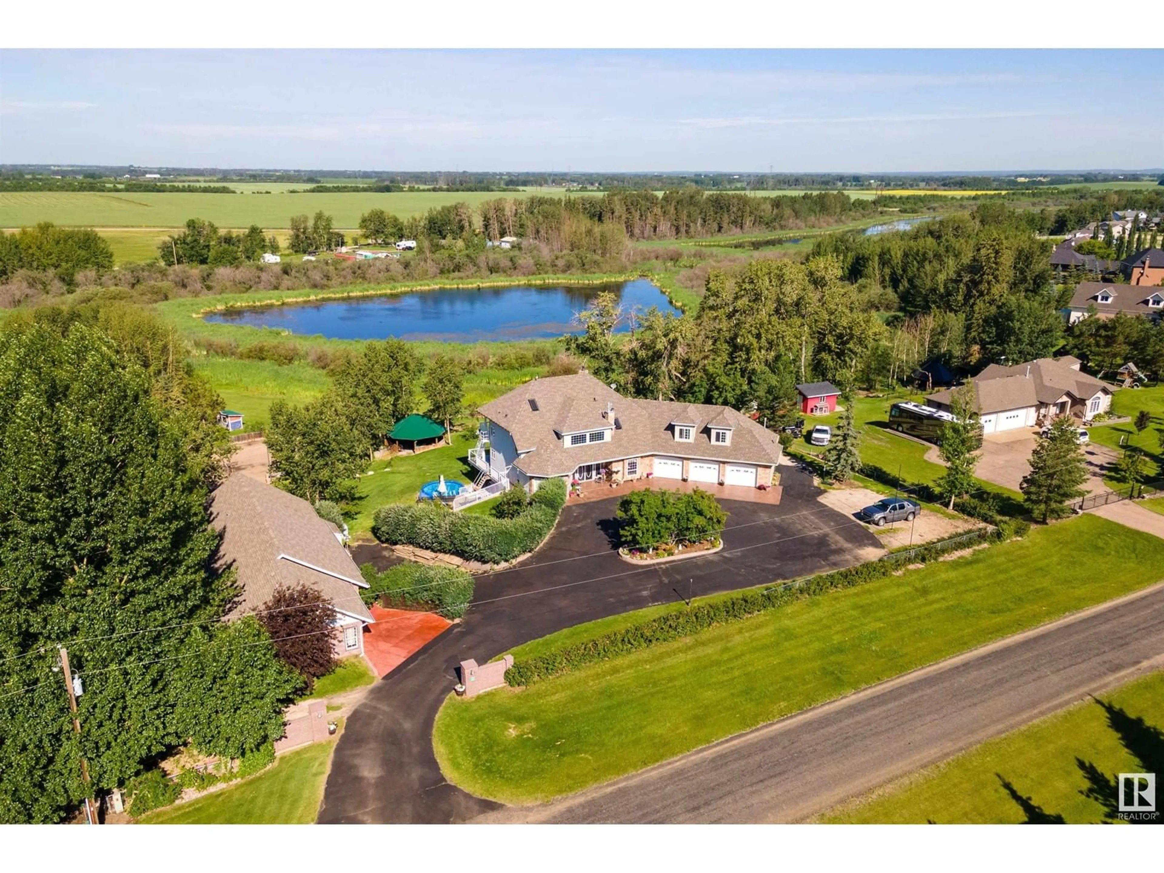 A pic from outside/outdoor area/front of a property/back of a property/a pic from drone, water/lake/river/ocean view for 4 - 52001 RGE RD 275, Rural Parkland County Alberta T7X3V2